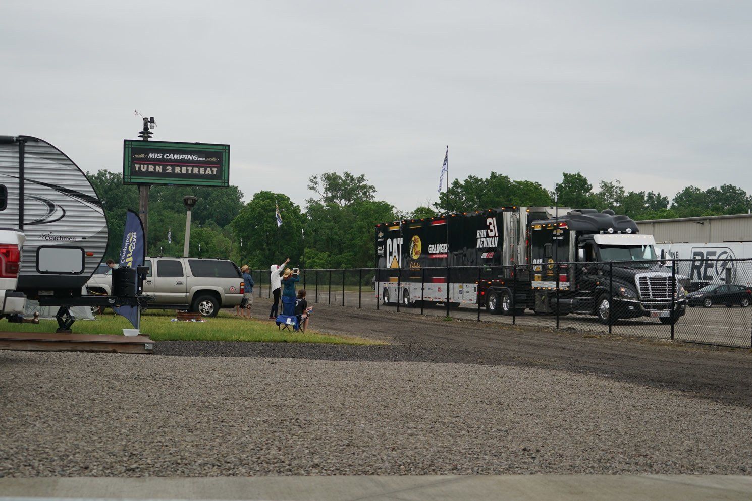 A lot of rv 's are parked in a gravel lot.