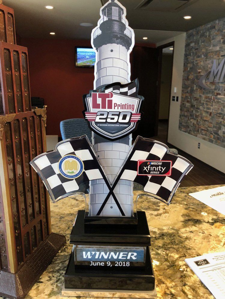 A trophy with a lighthouse and checkered flags on it is sitting on a table.