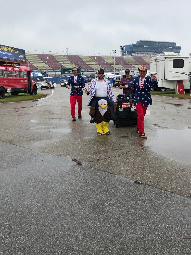 A group of men are walking down a wet road
