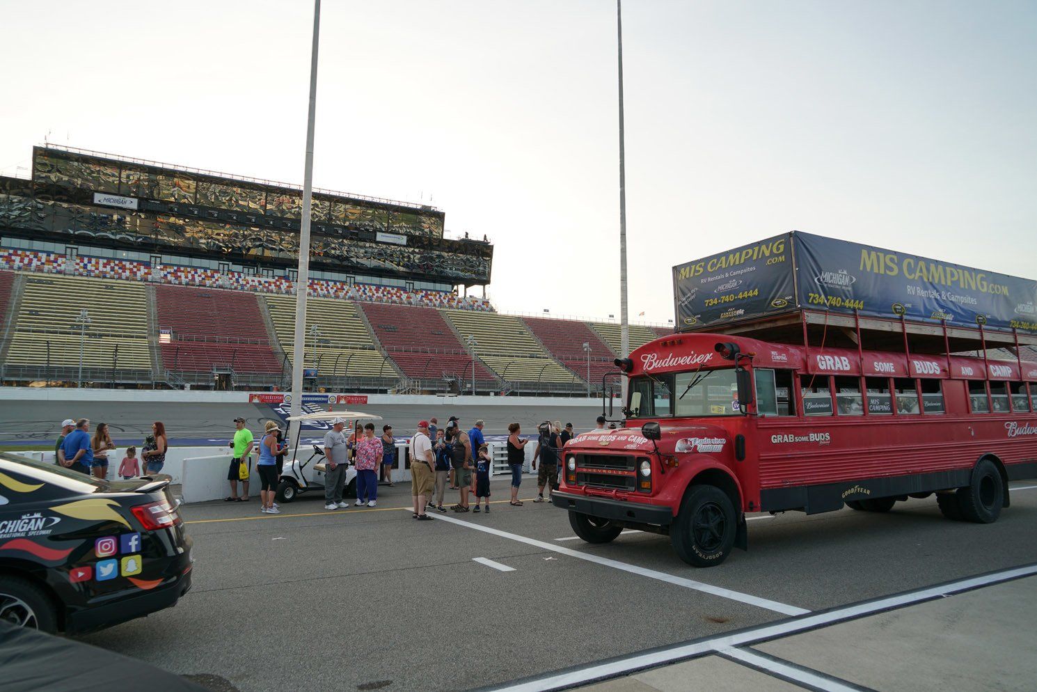 A red bus is parked in front of a stadium