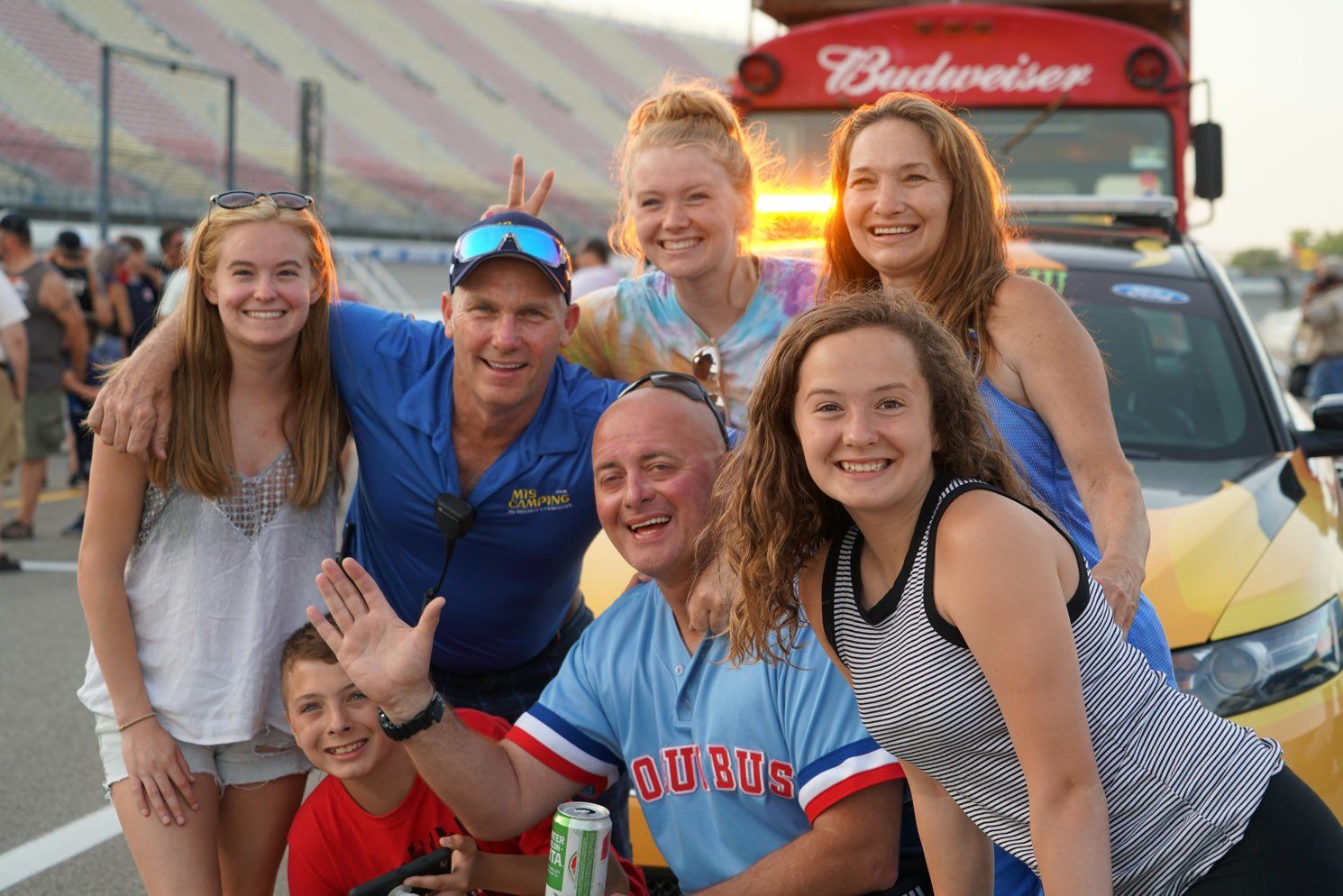 A group of people posing for a picture in front of a budweiser truck