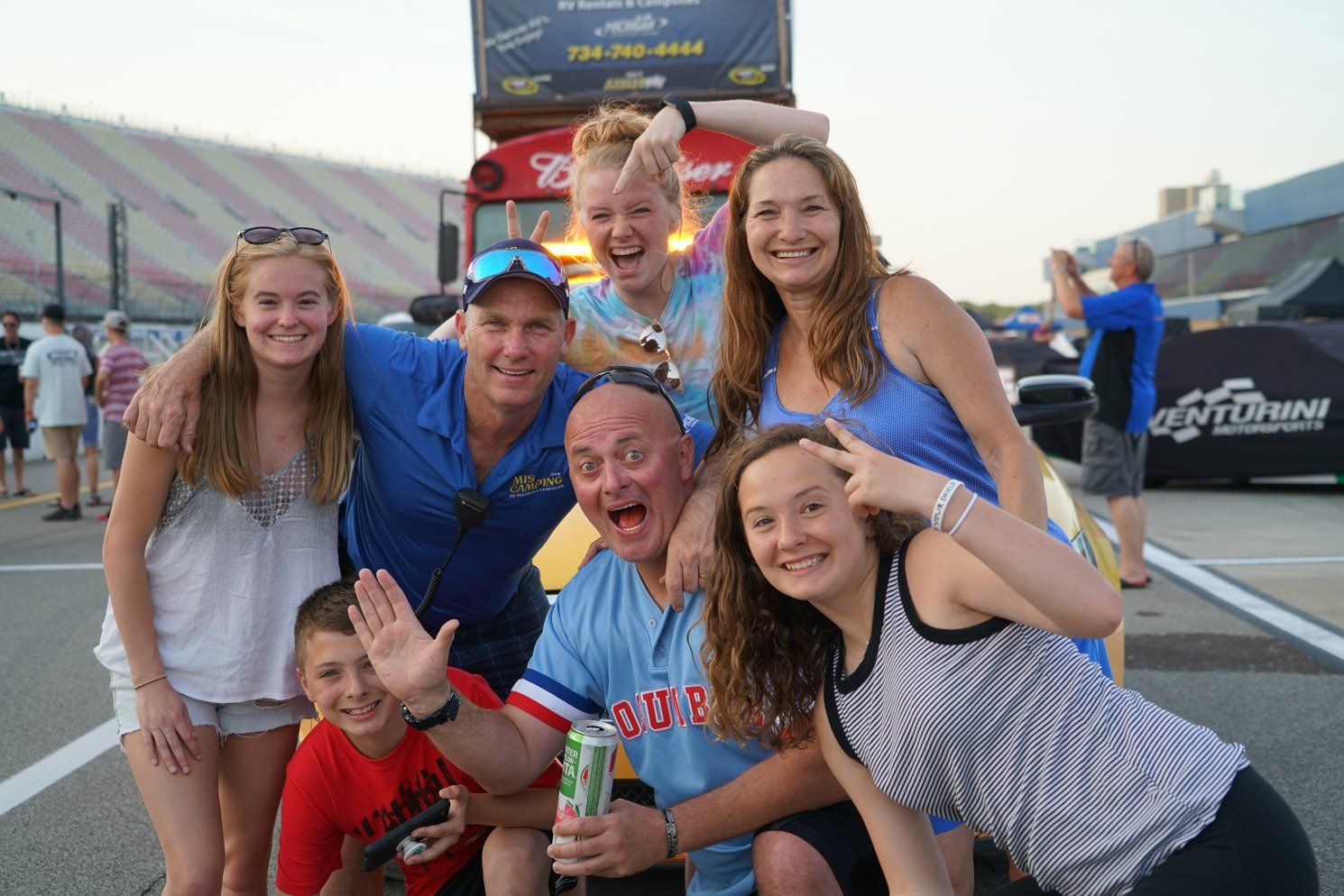 A group of people posing for a picture at a race track