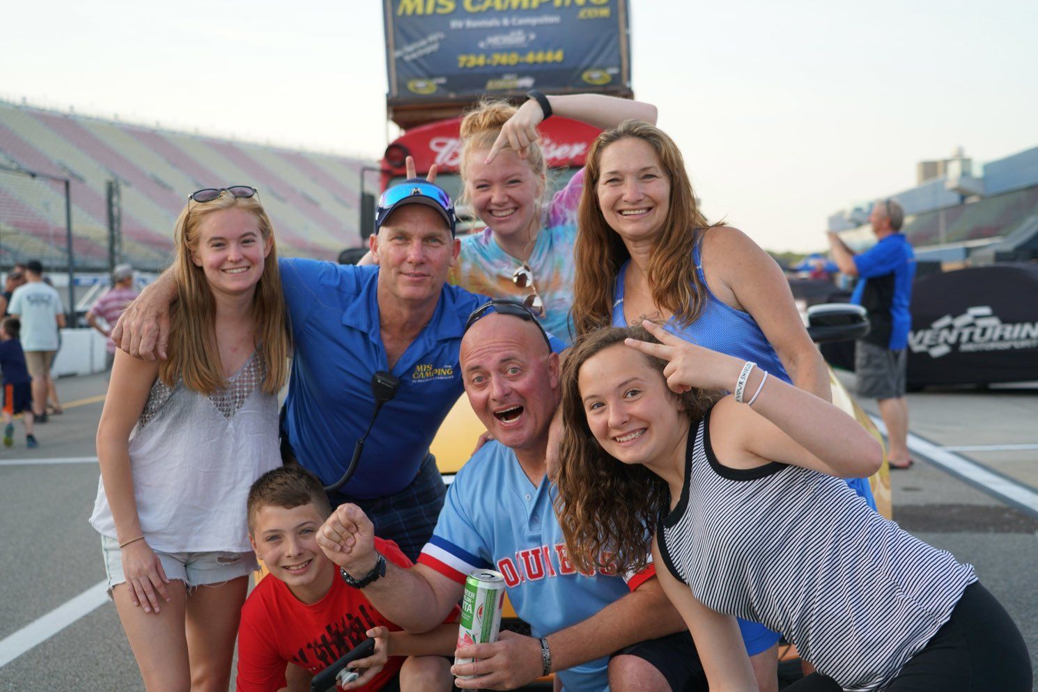 A group of people posing for a picture at a race track