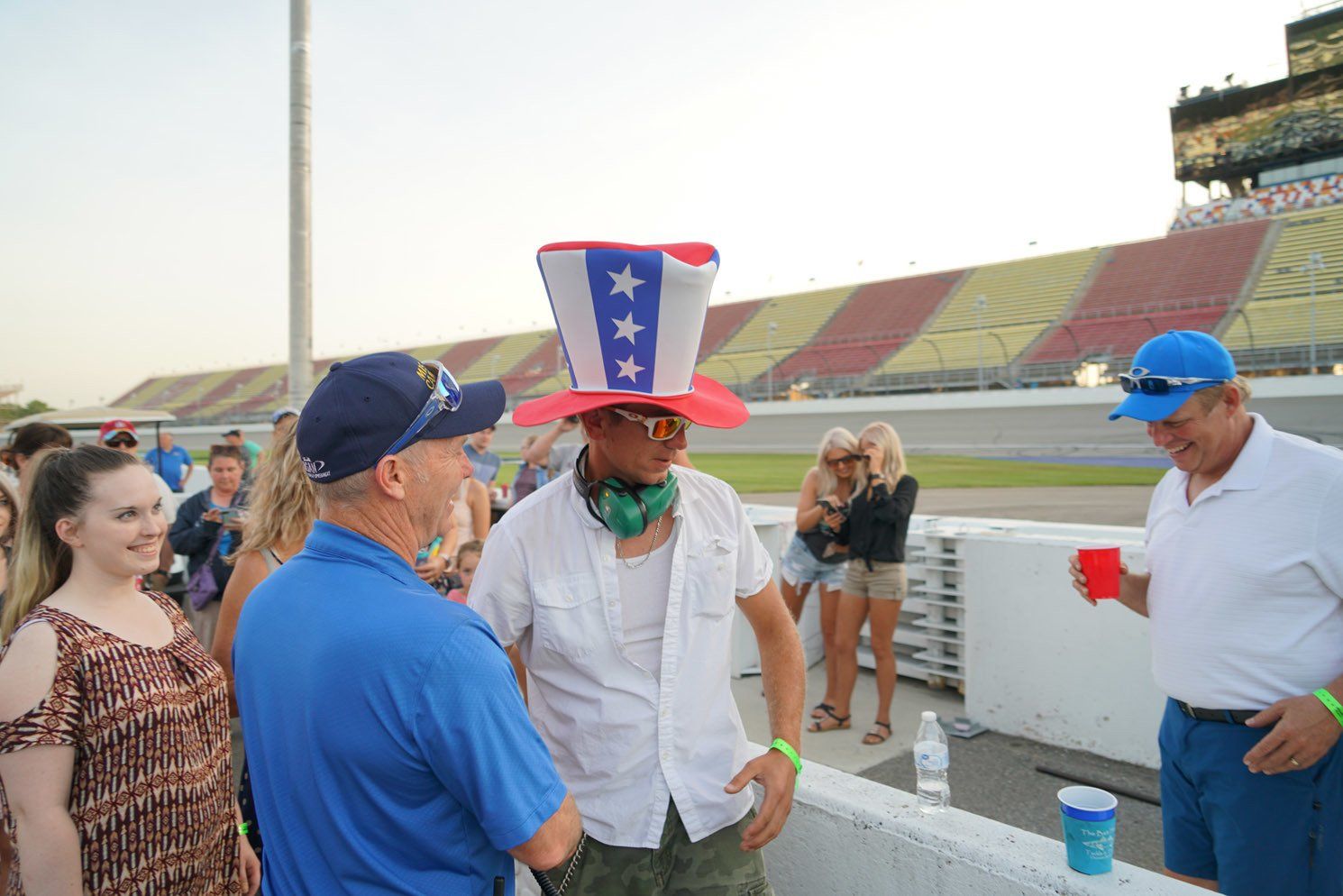 A man wearing an uncle sam hat is talking to another man