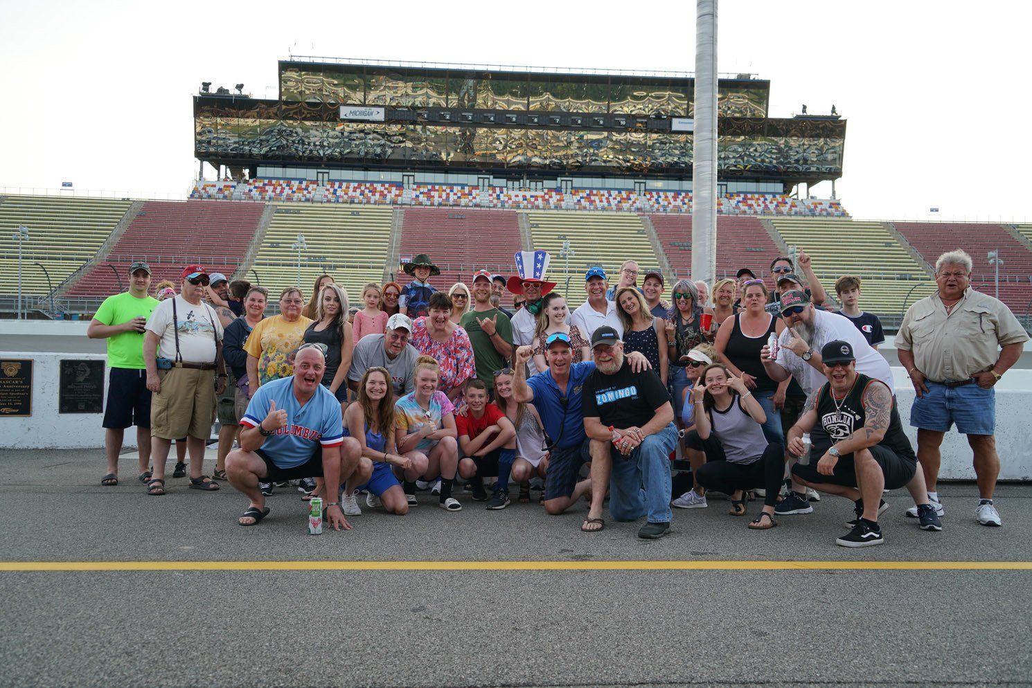 A group of people posing for a picture in front of a stadium