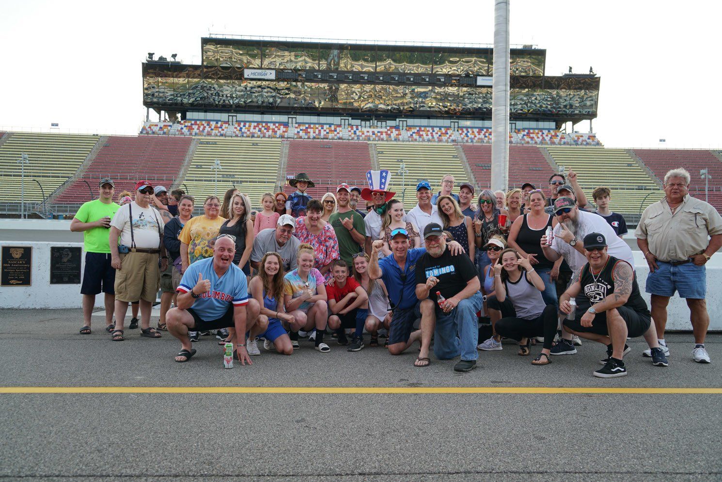 A group of people posing for a picture in front of a stadium