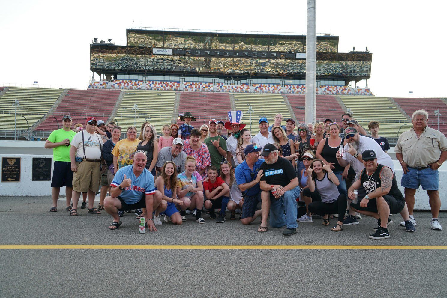 A group of people are posing for a picture in front of a stadium.