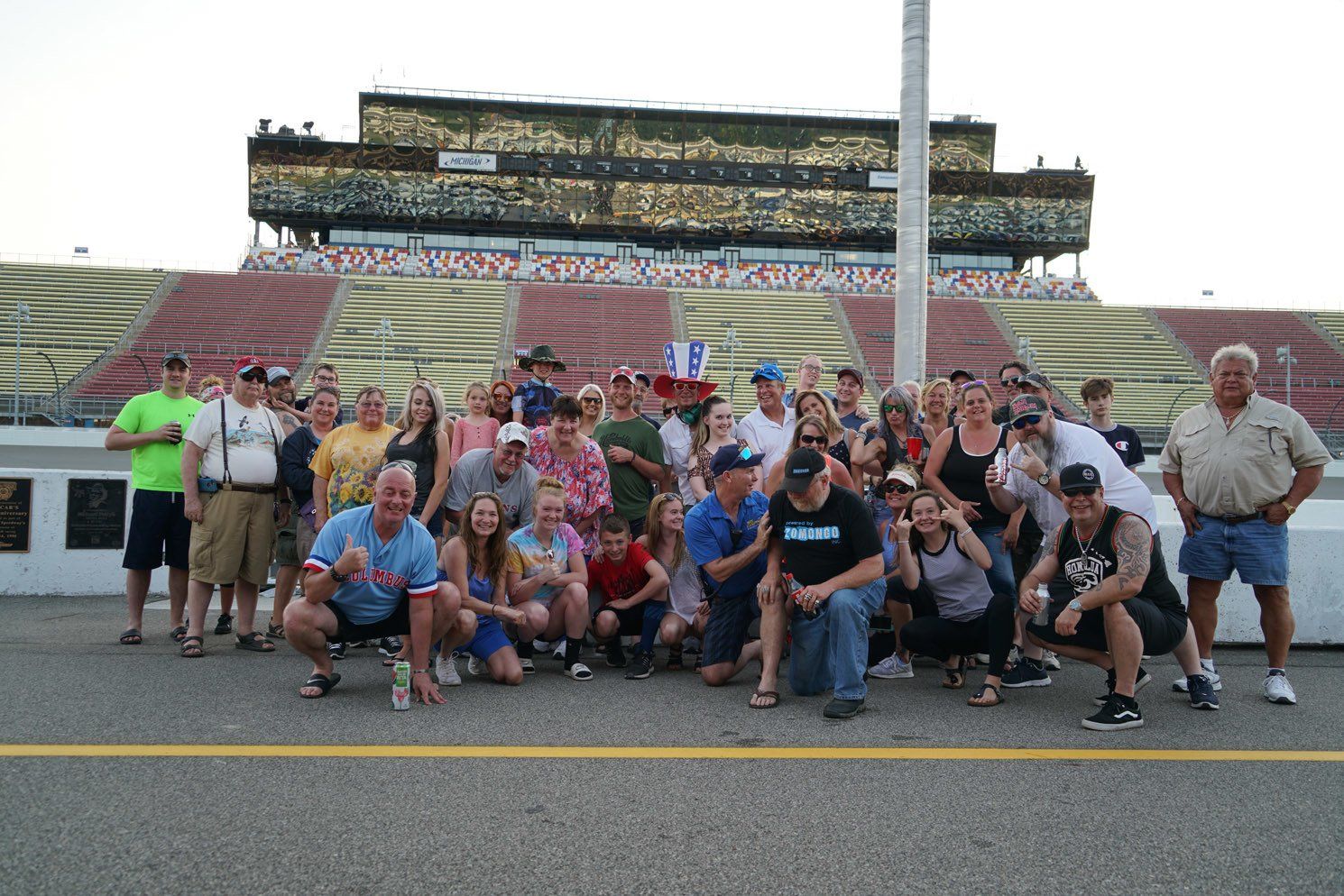 A group of people posing for a picture in front of a stadium