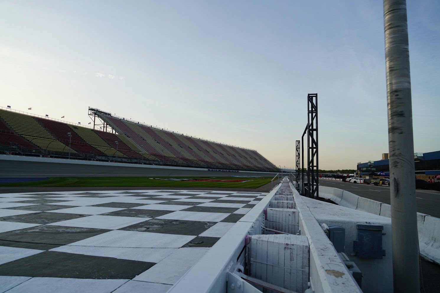 A race track with a checkered track and a stadium in the background.