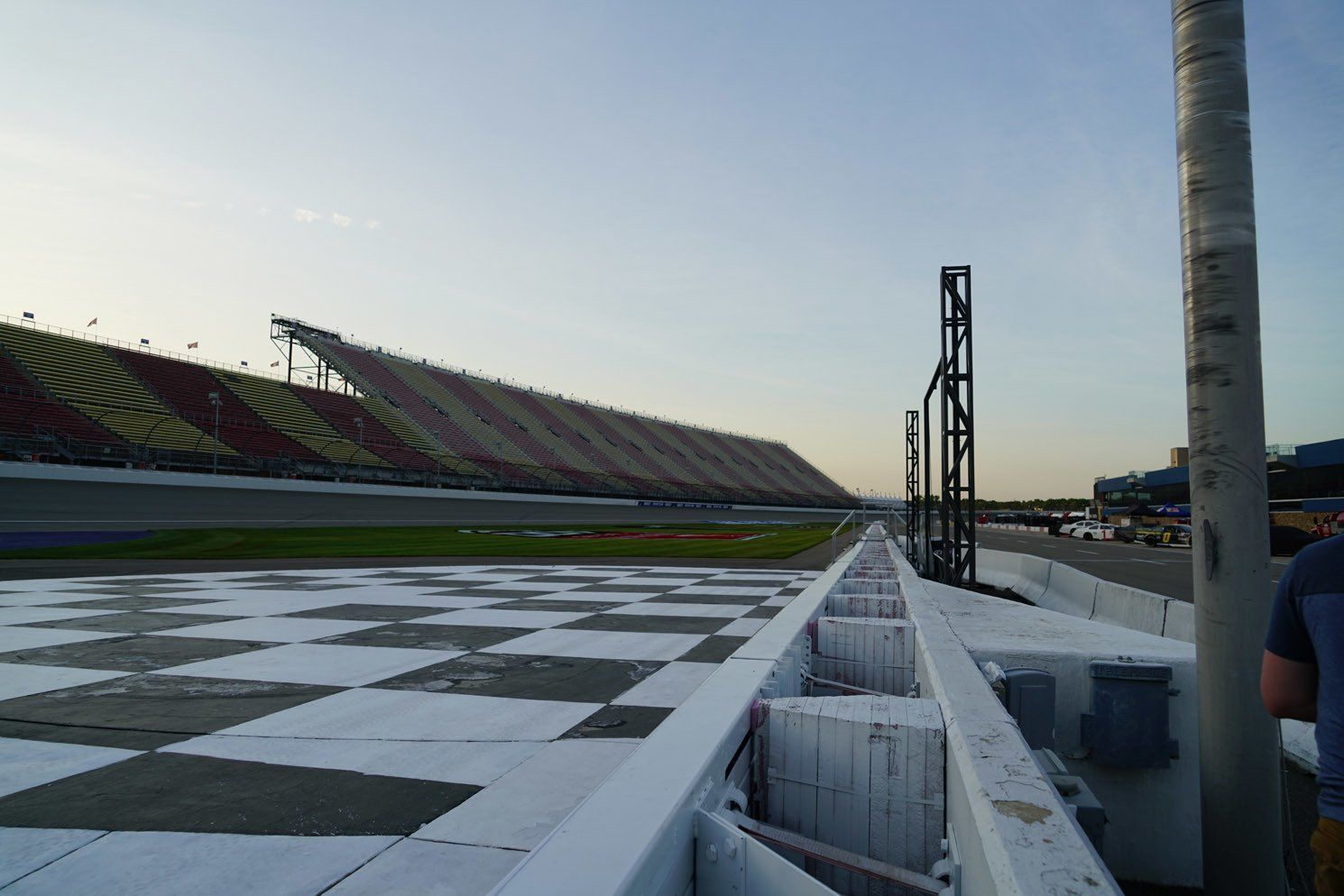 A race track with a checkered track and a stadium in the background.