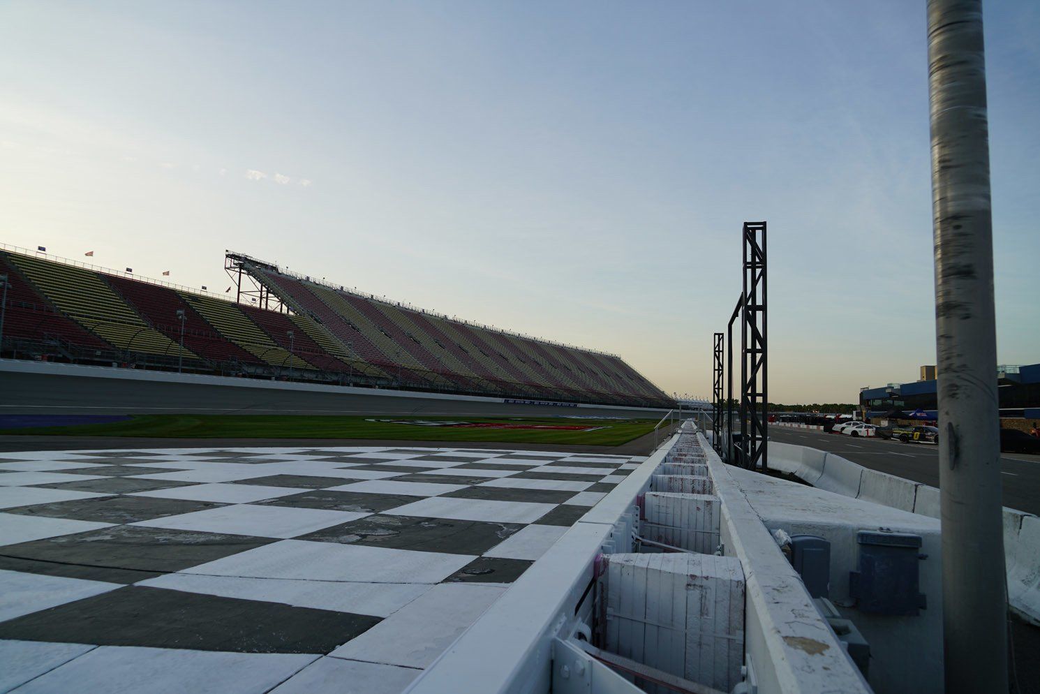 A race track with a checkered track and a stadium in the background.