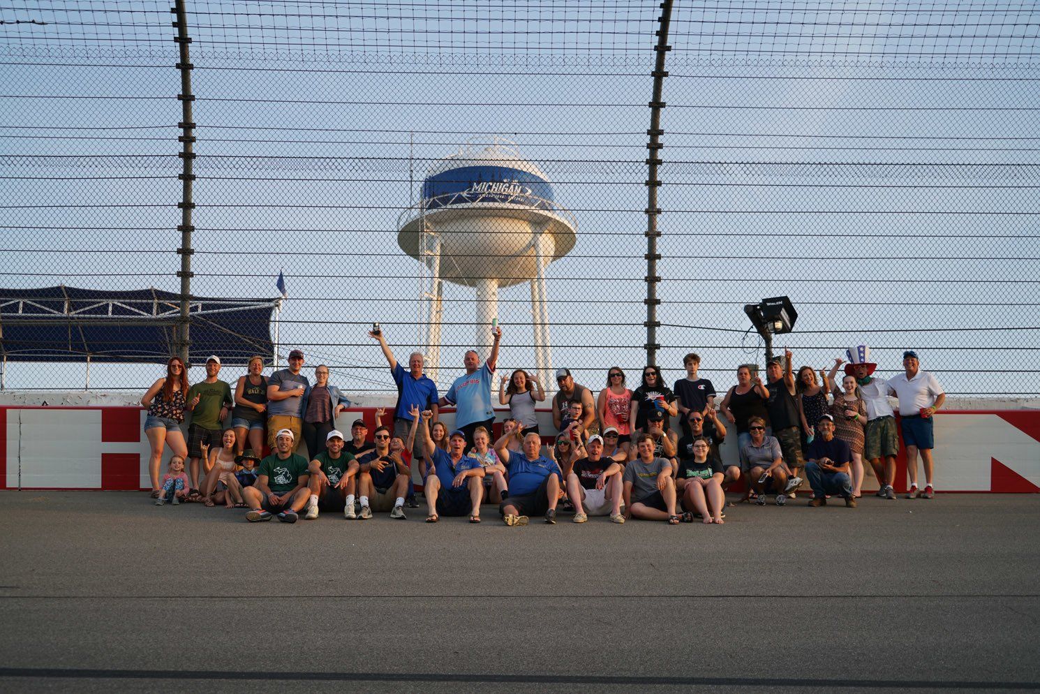 A group of people are posing for a picture on a race track.