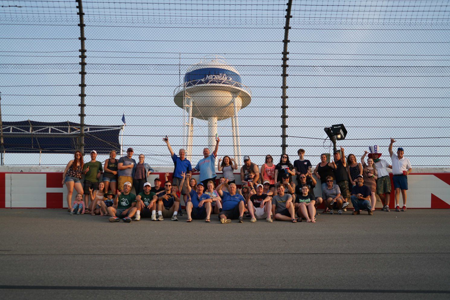 A group of people are posing for a picture on a race track.