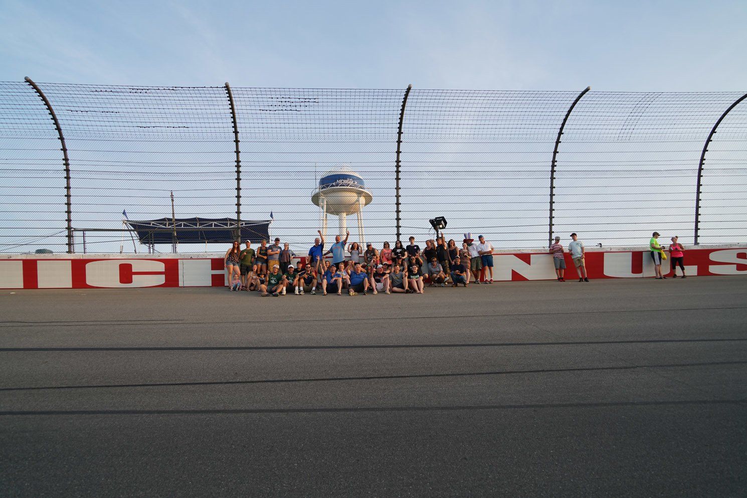 A group of people are posing for a picture on a race track