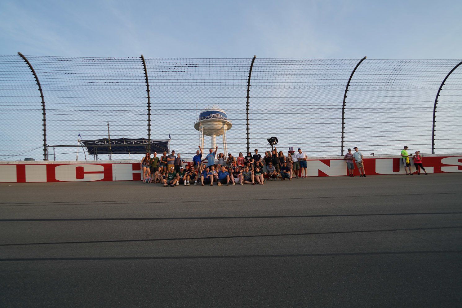 A group of people are posing for a picture on a race track