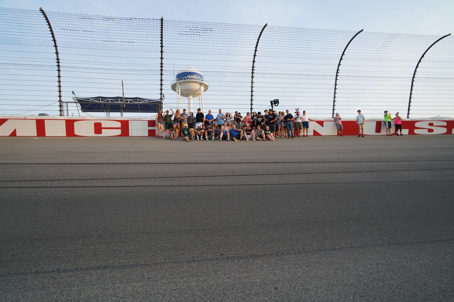 A group of people are posing for a picture on a race track