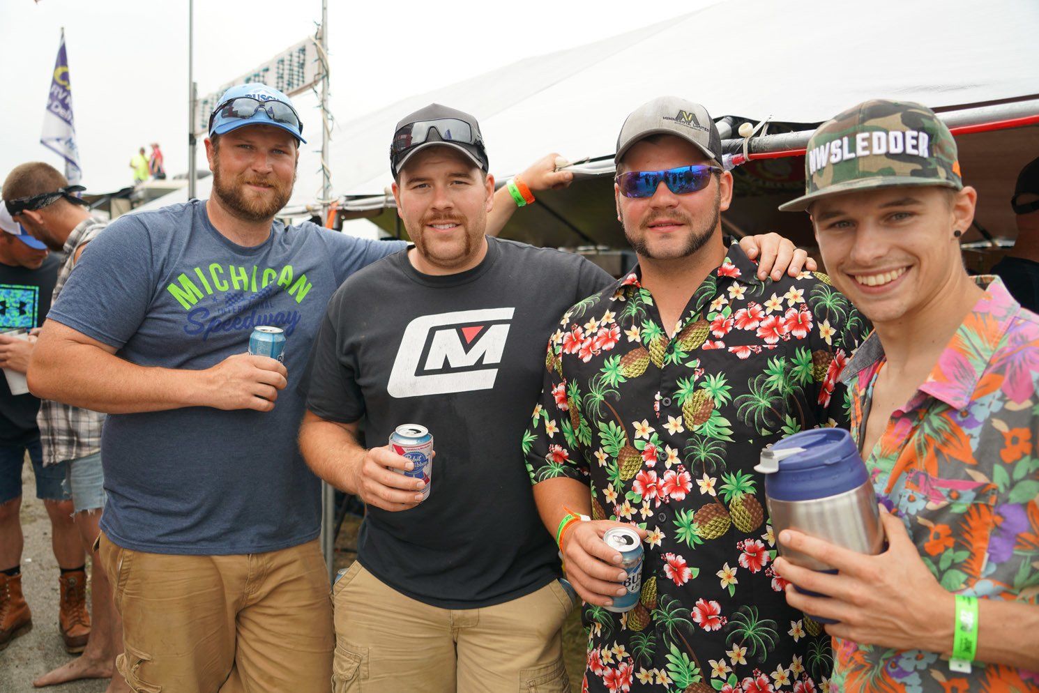 A group of men are posing for a picture and one of them is wearing a michigan shirt