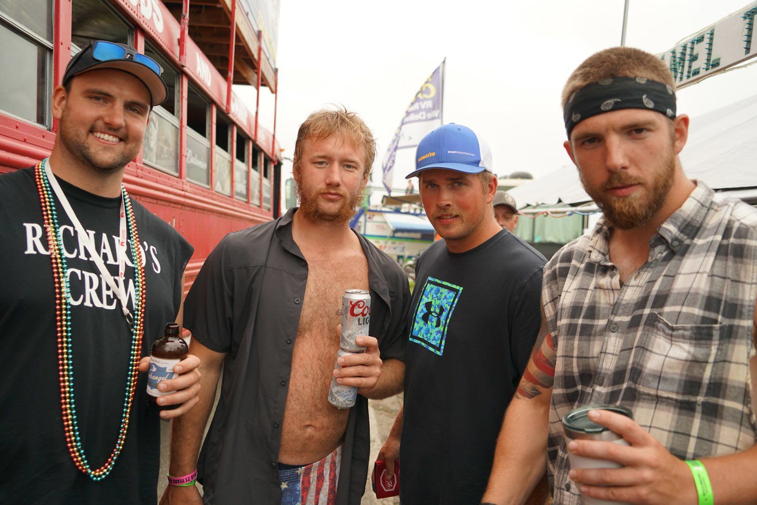 Four men standing next to each other with one wearing a shirt that says richard 's crew