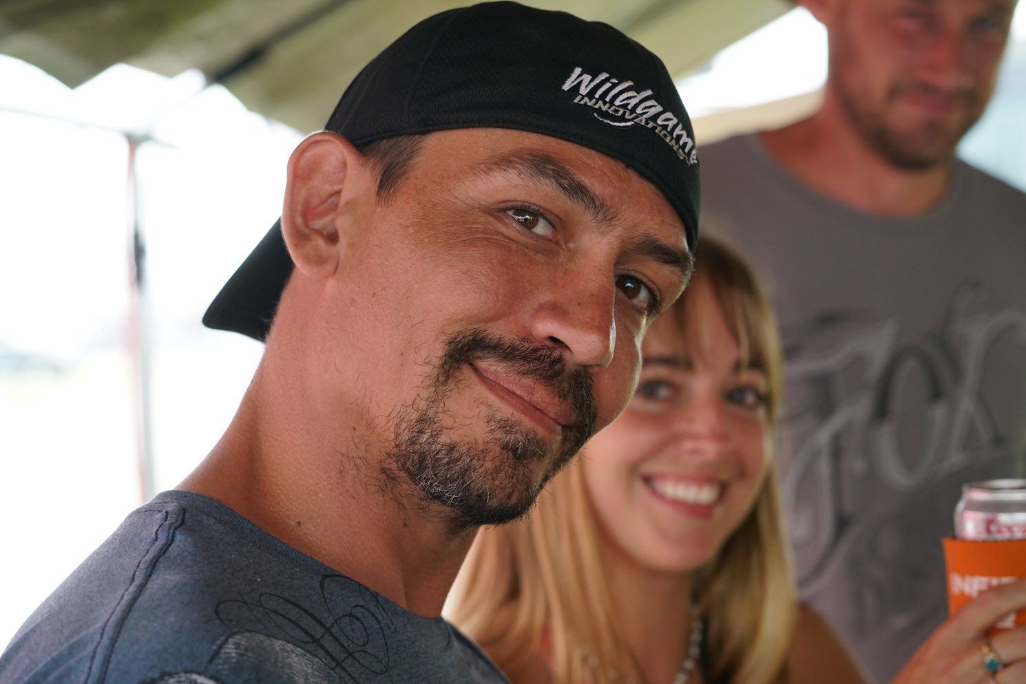 A man wearing a wilderness hat stands next to a woman