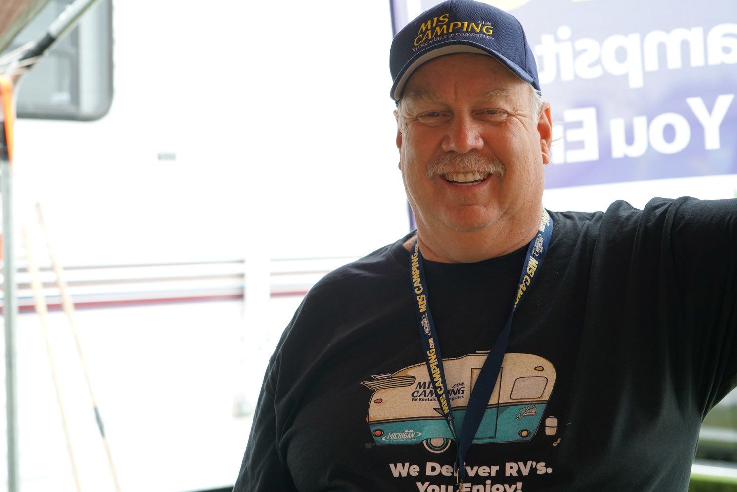 A man wearing a shirt that says we deliver rvs