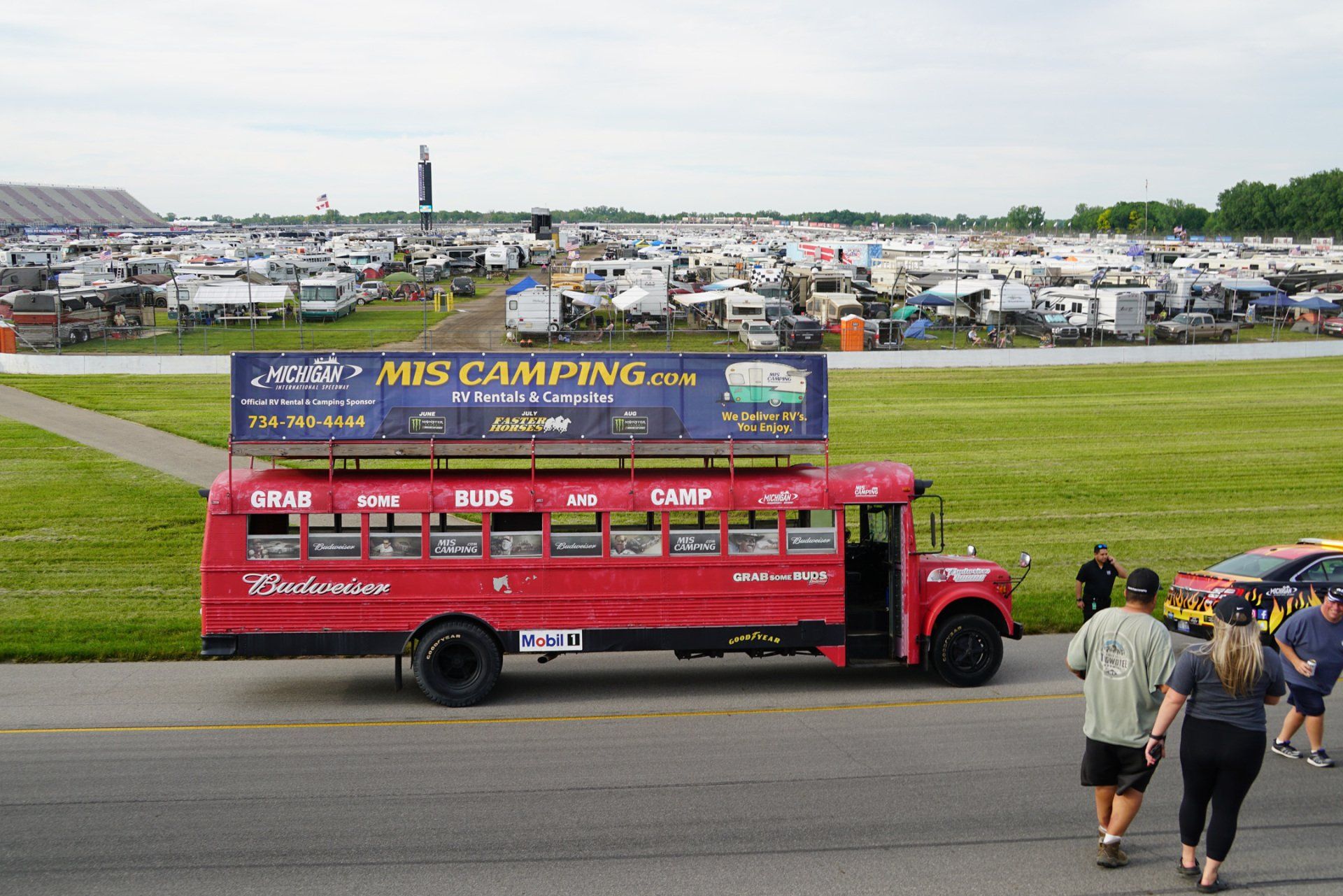 A red bus with a sign on top that says mis camping