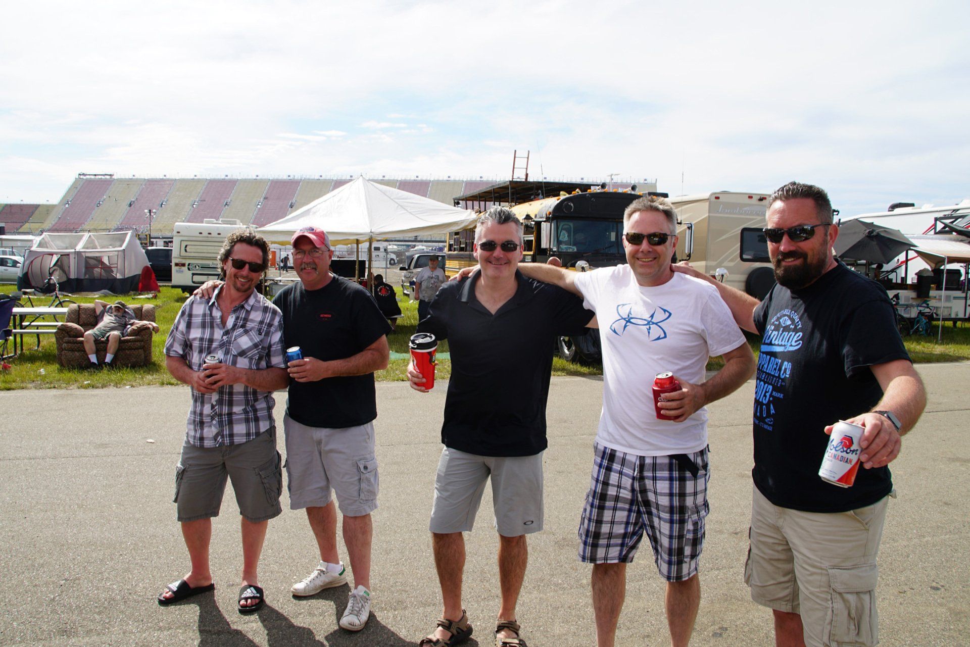 A group of men are posing for a picture in a parking lot