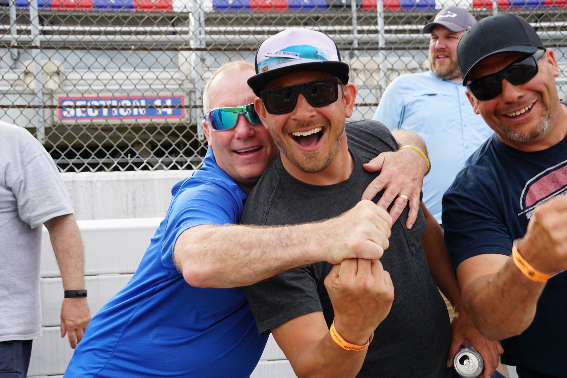 A group of men are posing for a picture and one of them is wearing sunglasses.