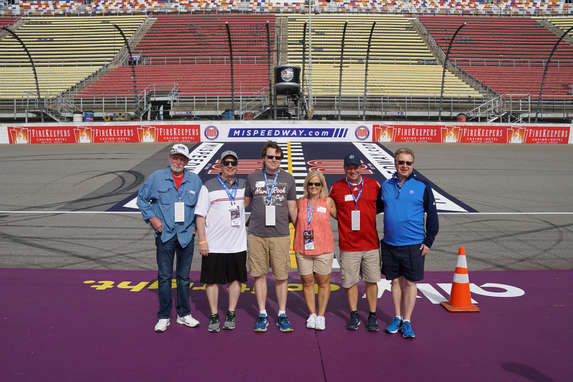 A group of people posing for a picture on a race track