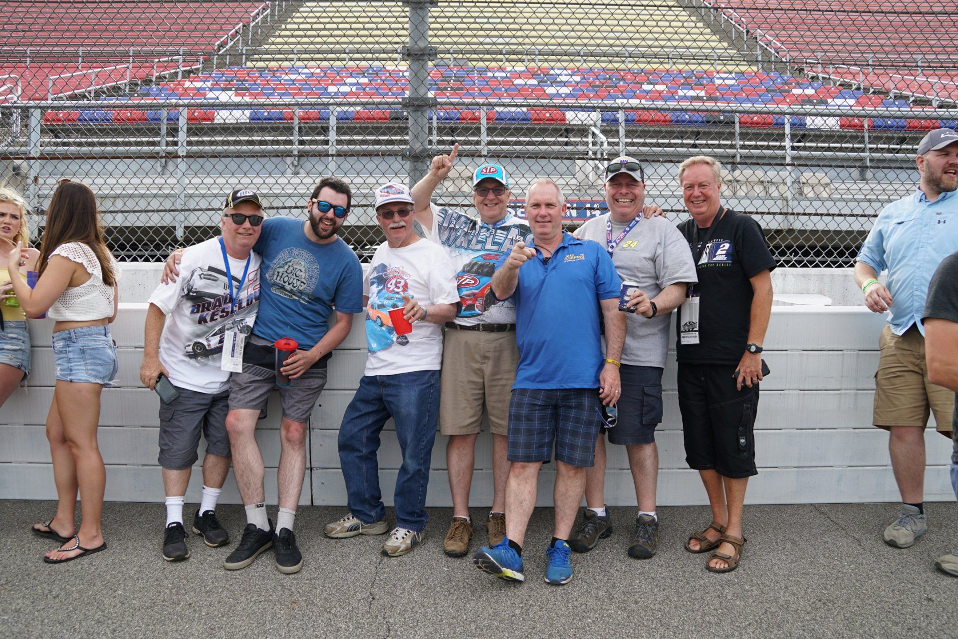 A group of people are posing for a picture on a race track