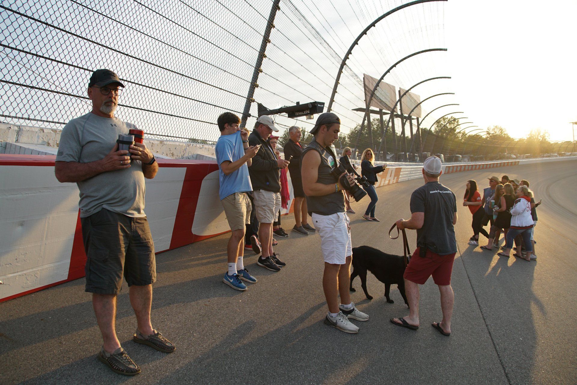 A group of people standing on a race track with a dog