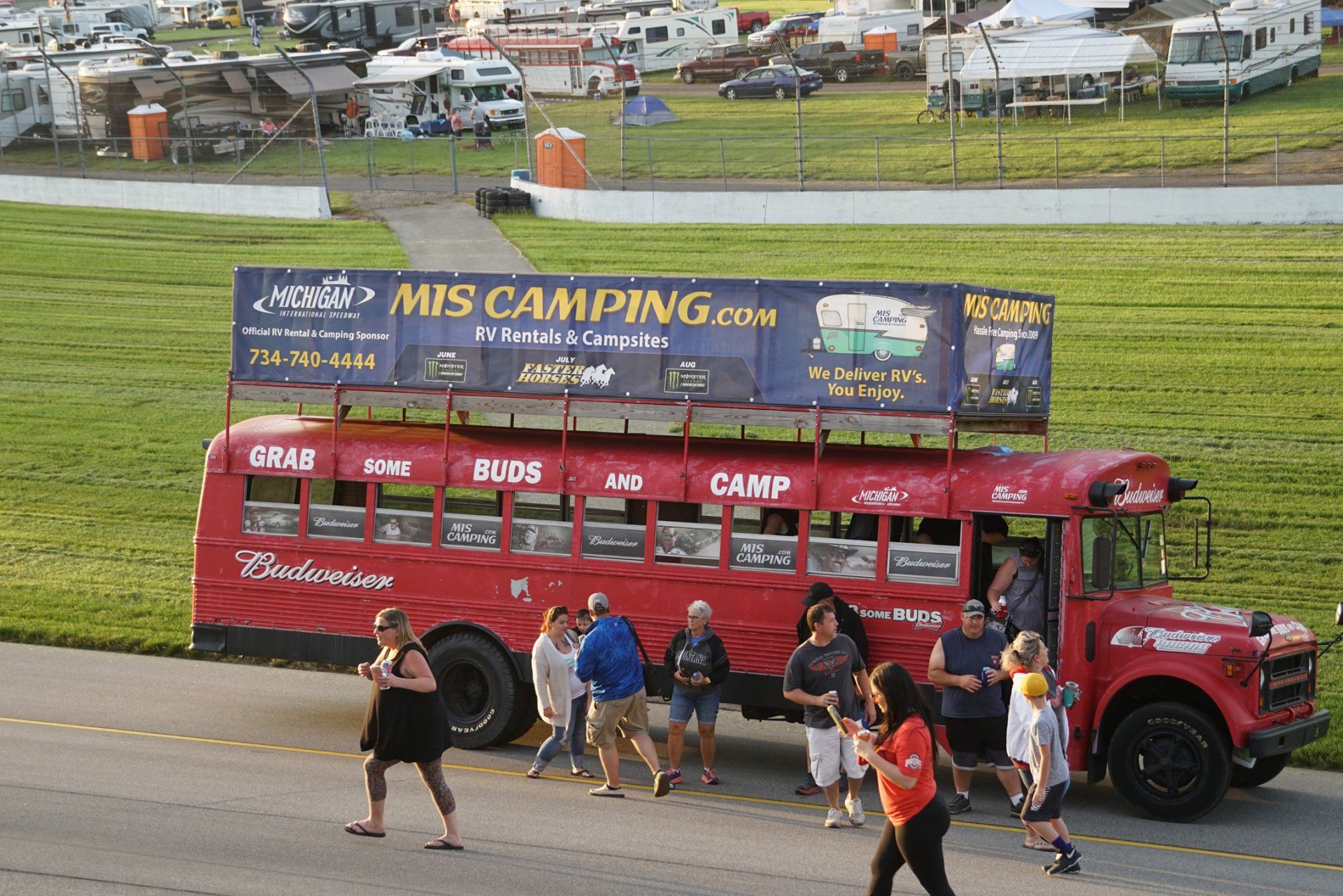 A red bus with a sign on top that says mis camping.com