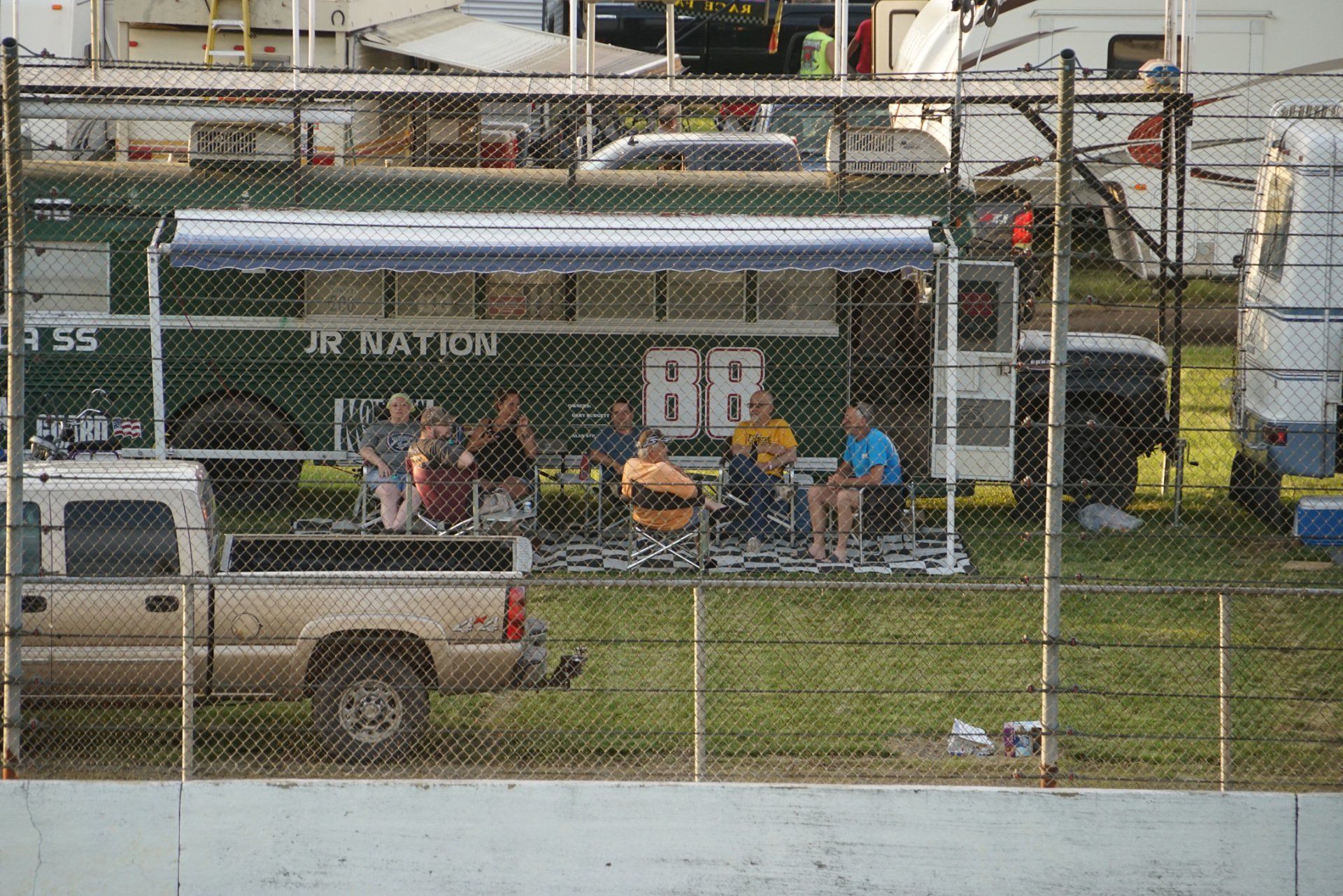 A group of people are sitting under an awning in front of a bus that says br.
