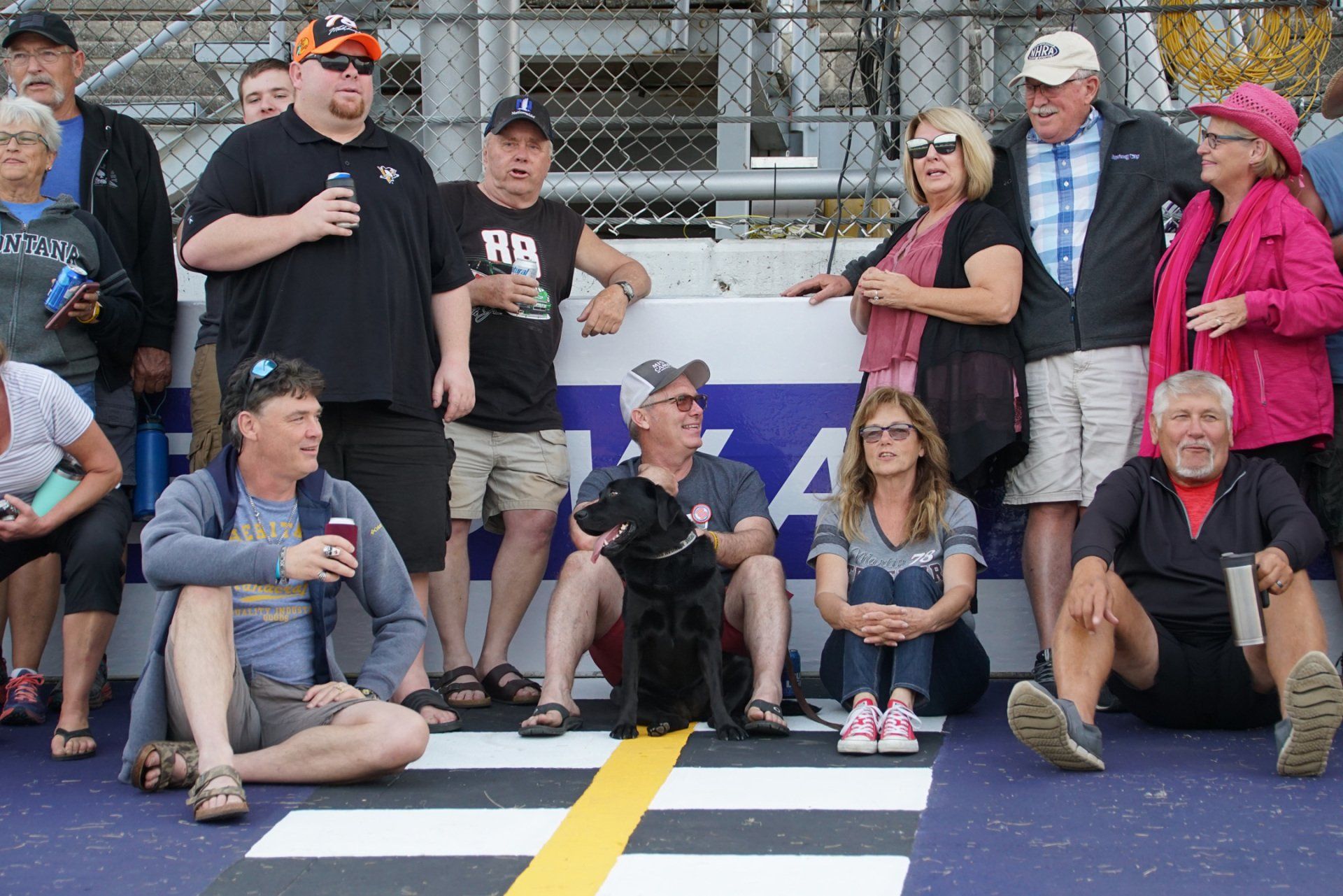 A group of people are posing for a picture in front of a sign that has the letter a on it
