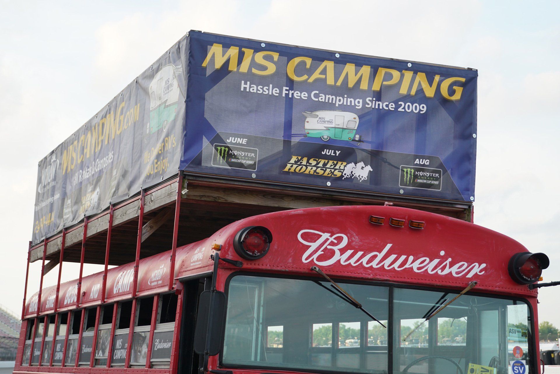 A red bus with the word budweiser on it