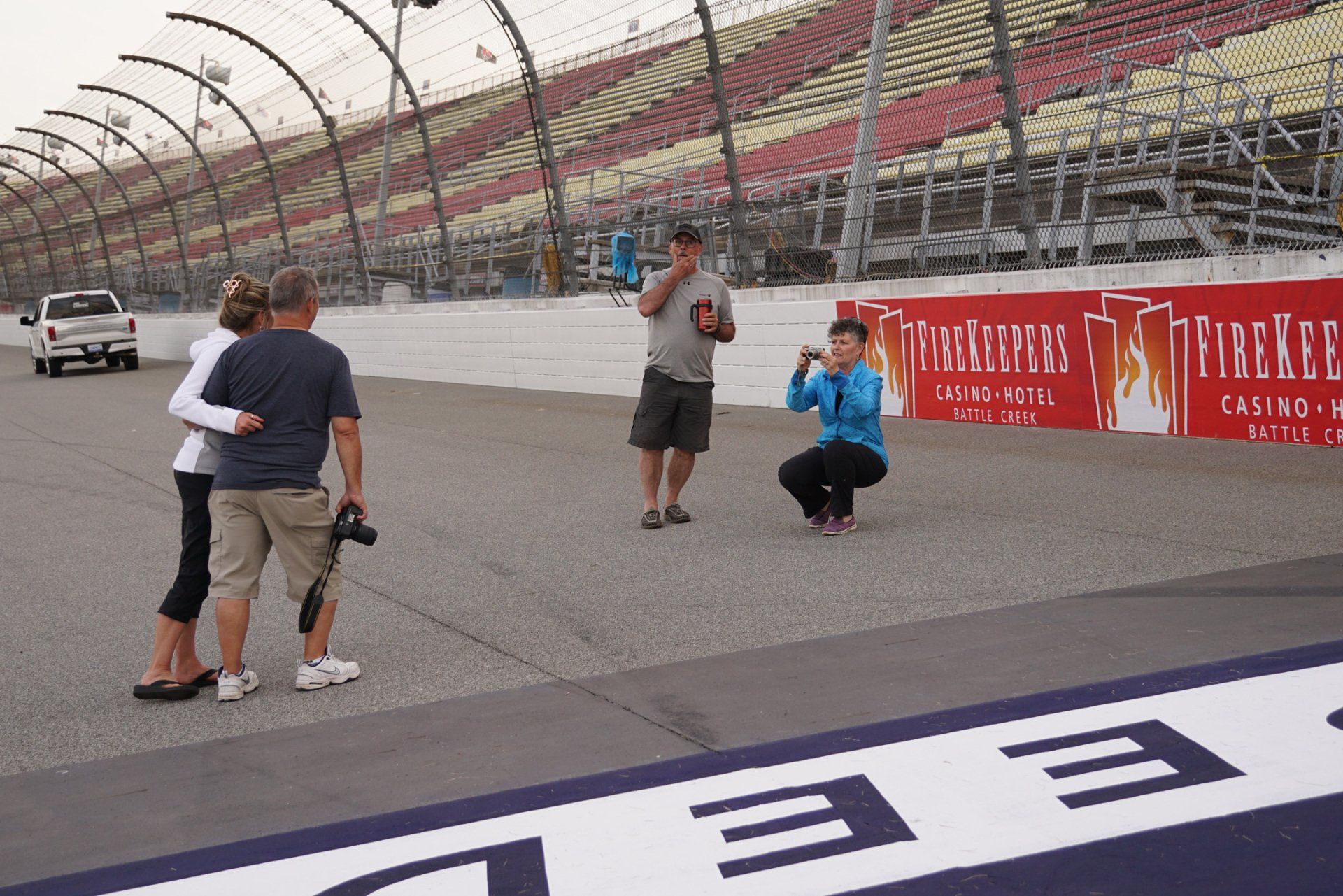 A man taking a picture of a woman on a race track
