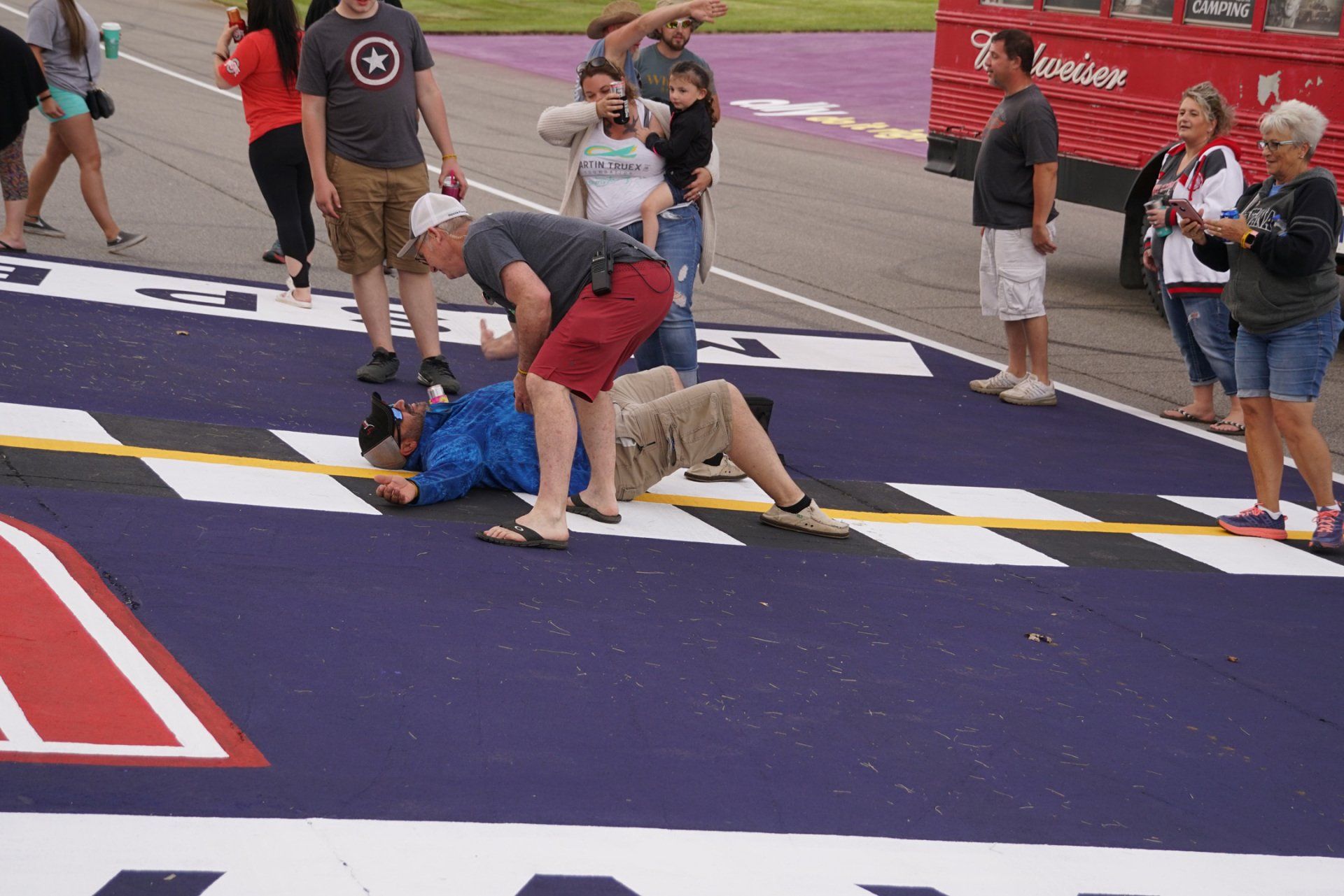 A group of people are standing around a race track