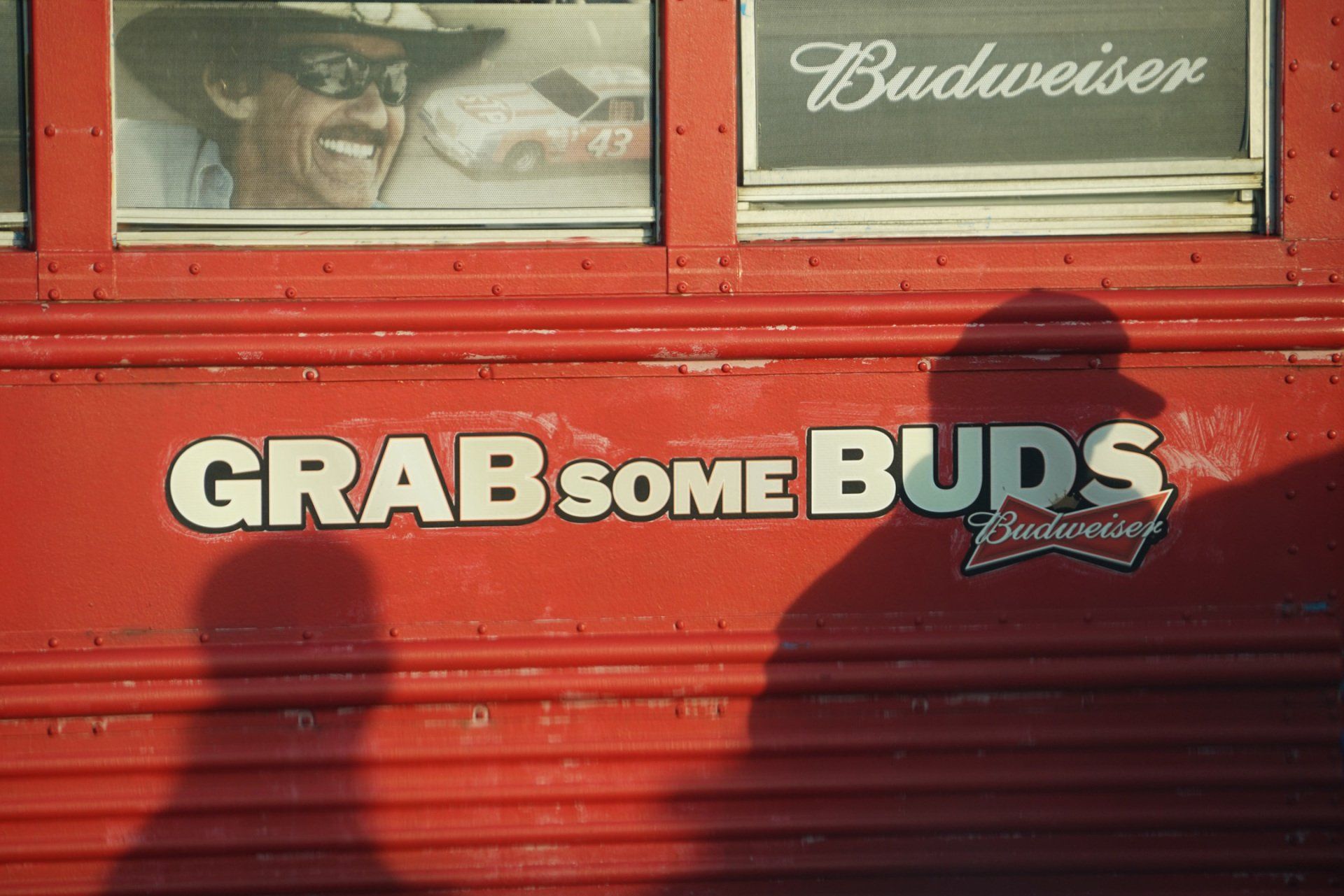 A red bus with a budweiser ad on it