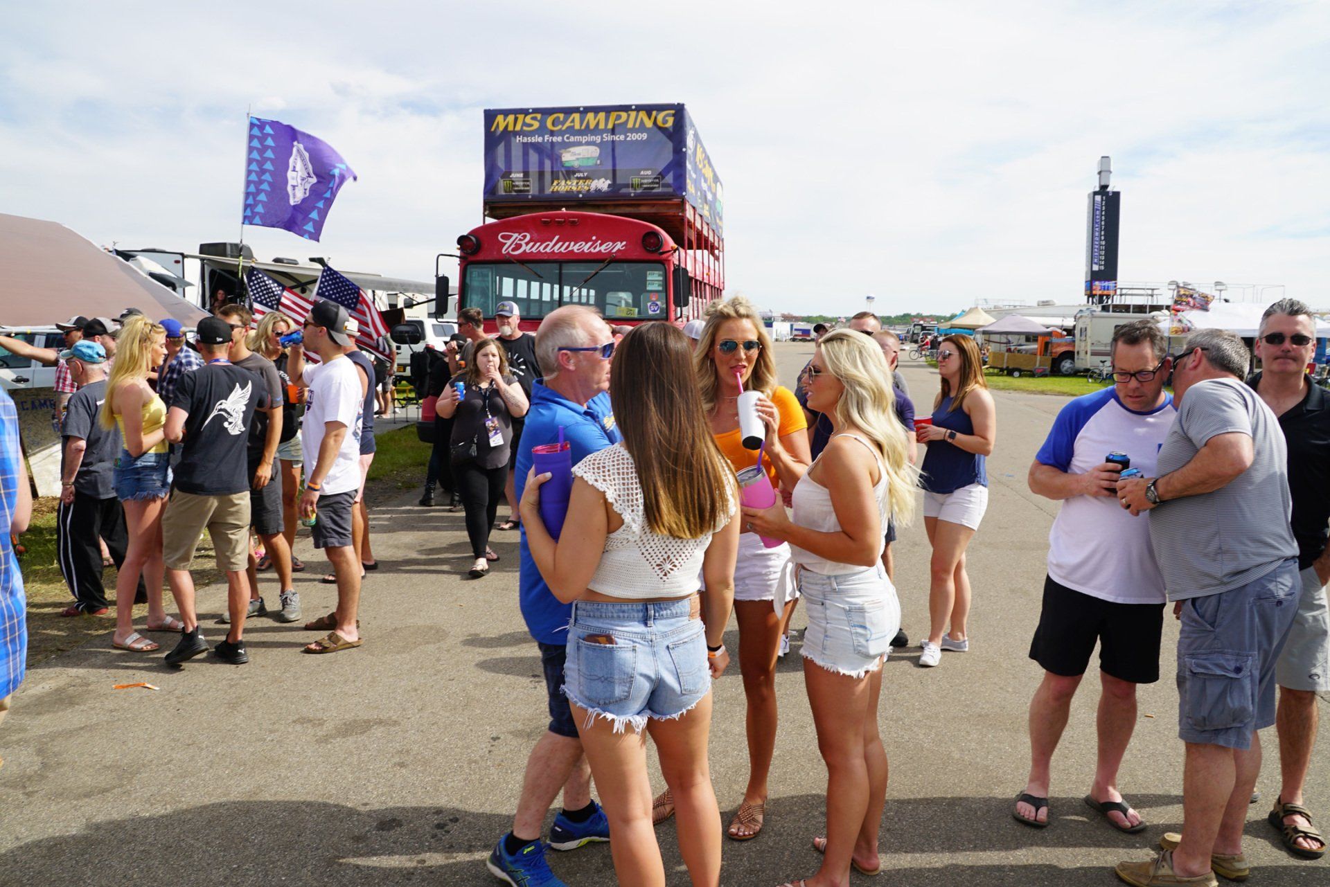 A group of people are standing in front of a double decker bus.