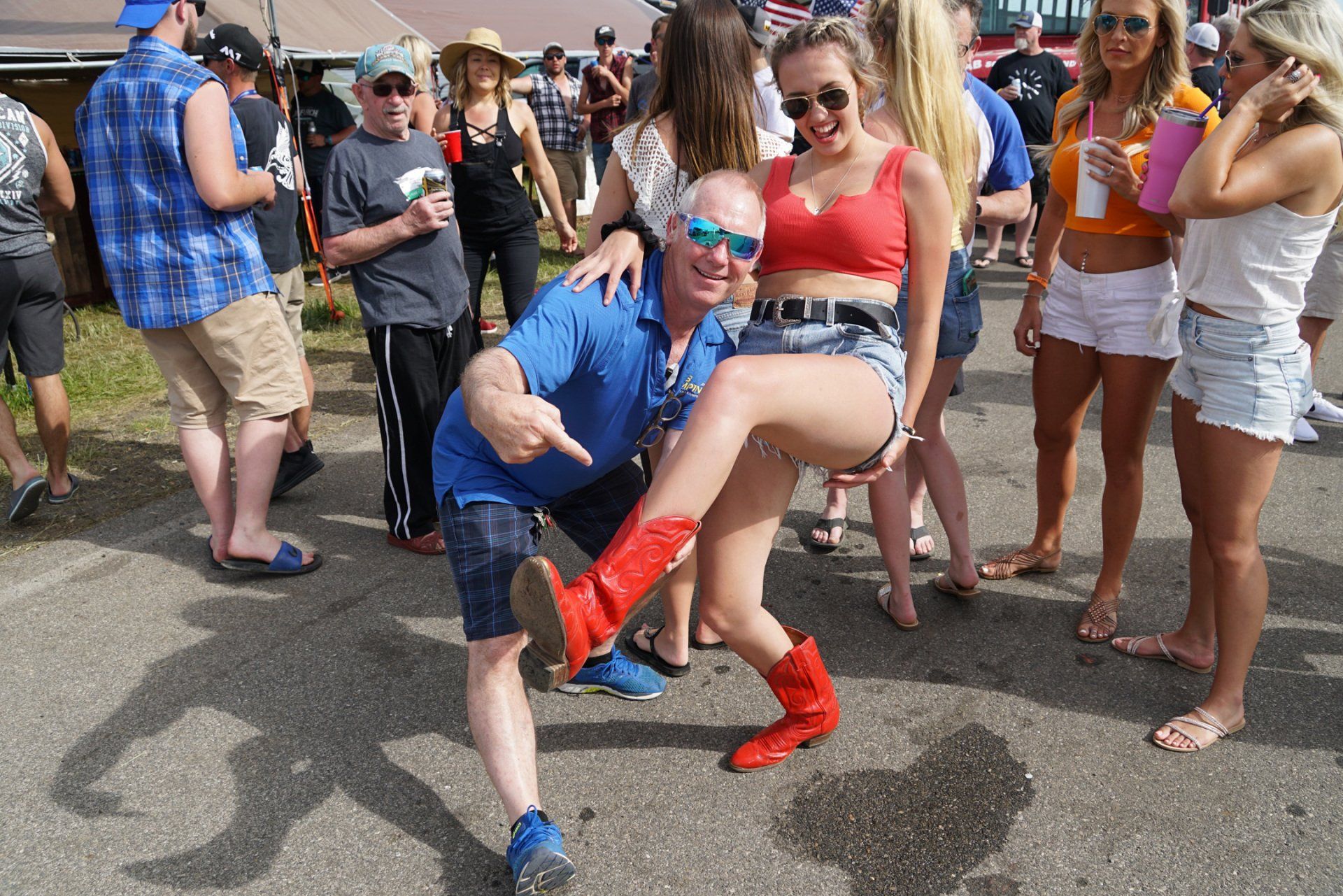 A man is holding a woman in his arms in a crowd of people.