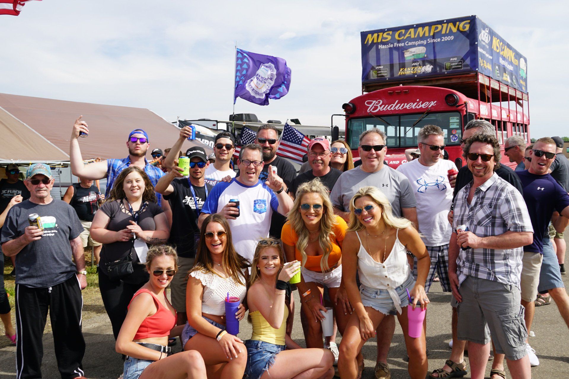 A group of people standing in front of a budweiser truck