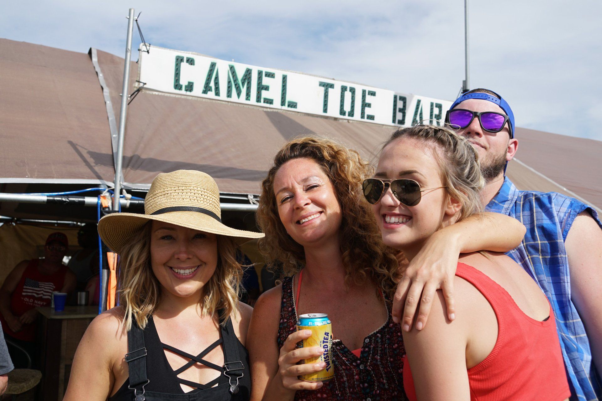 A group of people standing in front of a camel toe bar