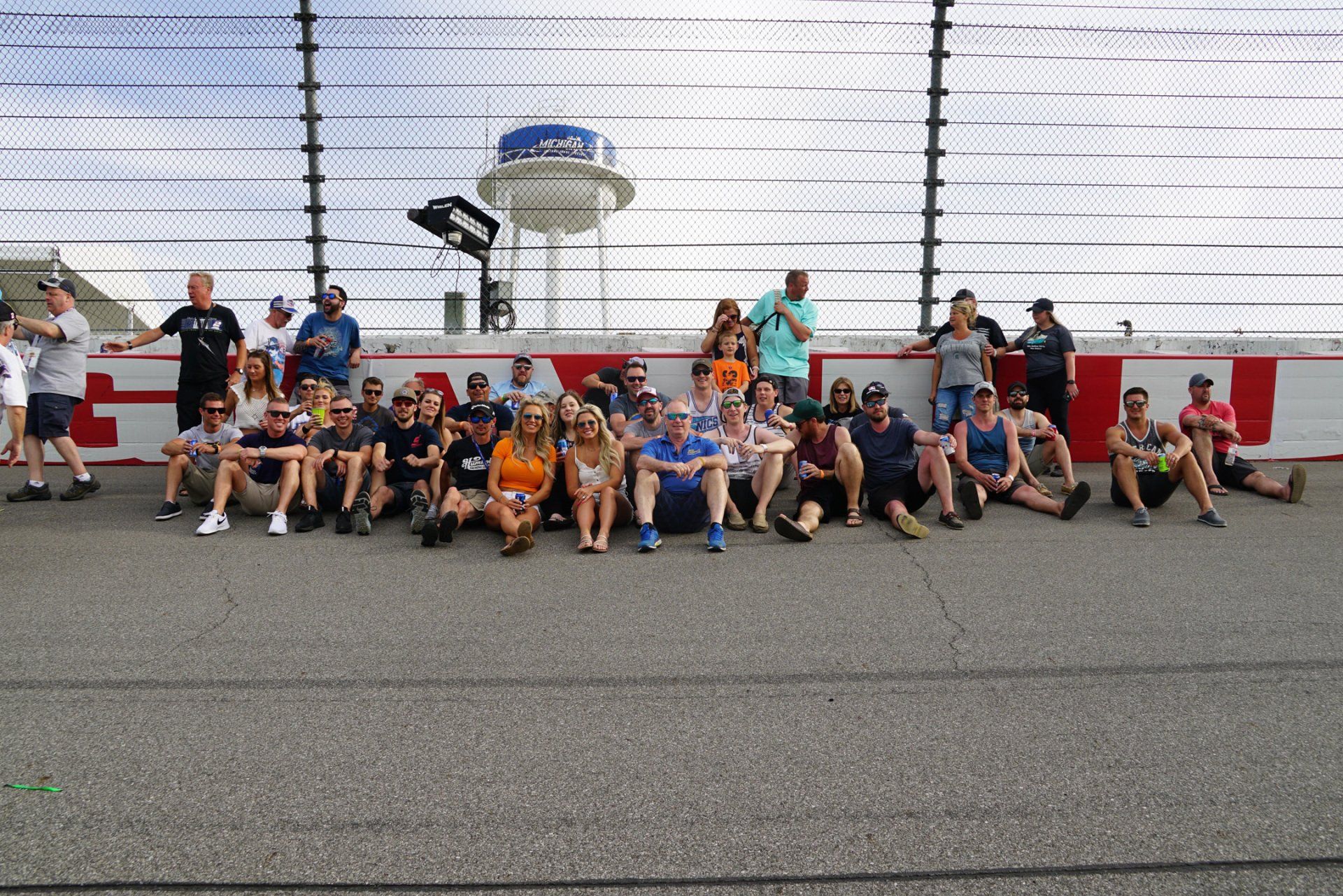 A group of people are posing for a picture on a race track