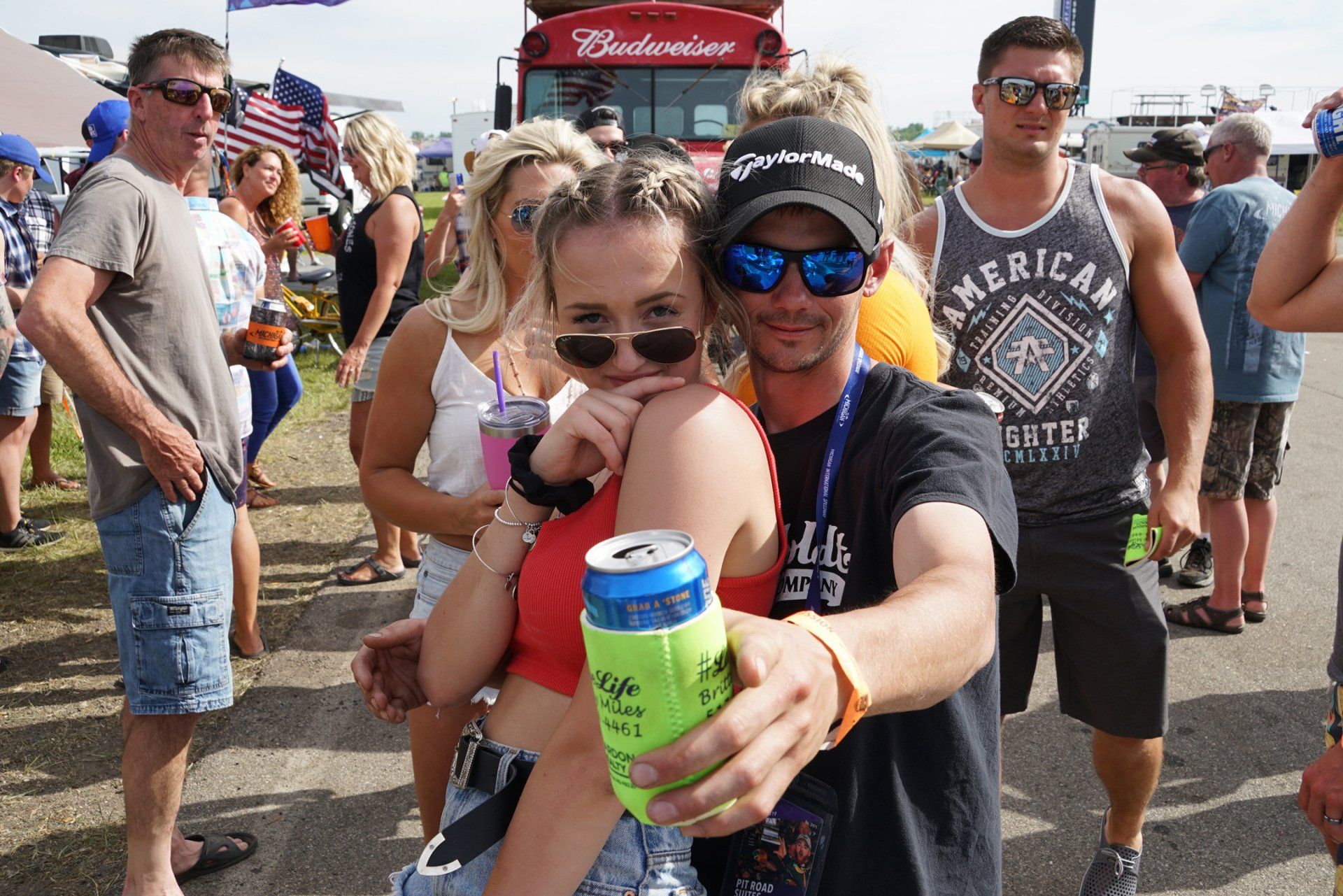 A man is holding a can of beer next to a woman.