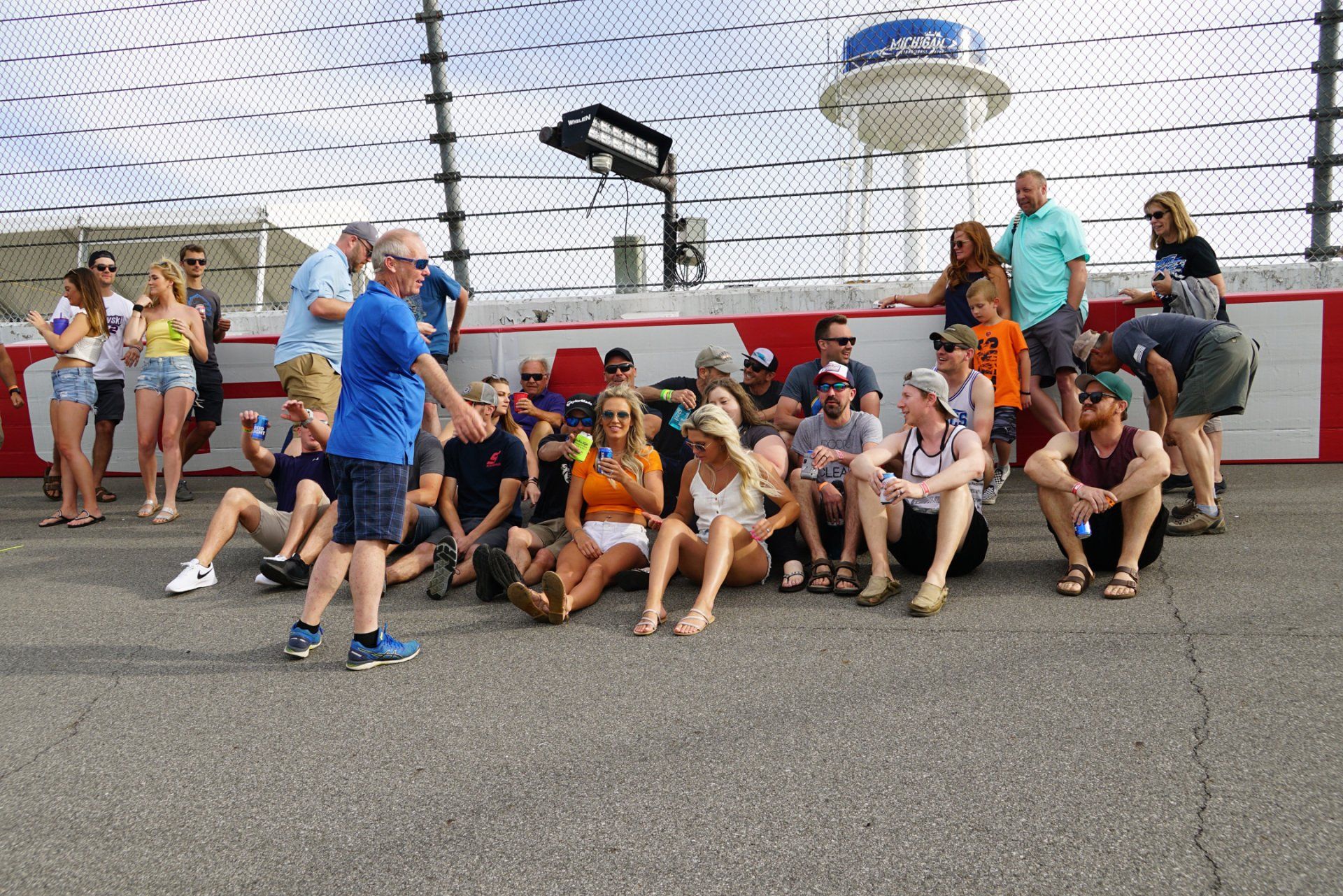 A group of people are posing for a picture in front of a race track.