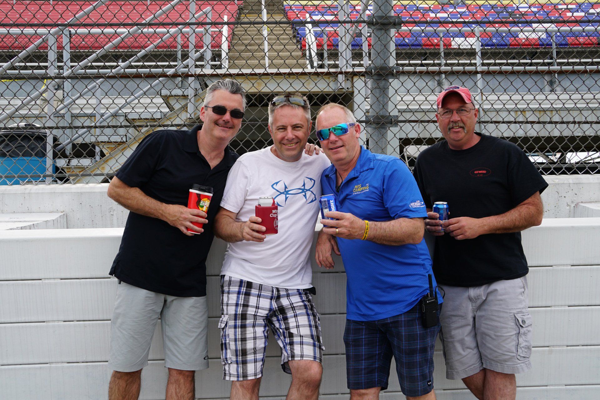 A group of men standing next to each other holding drinks.