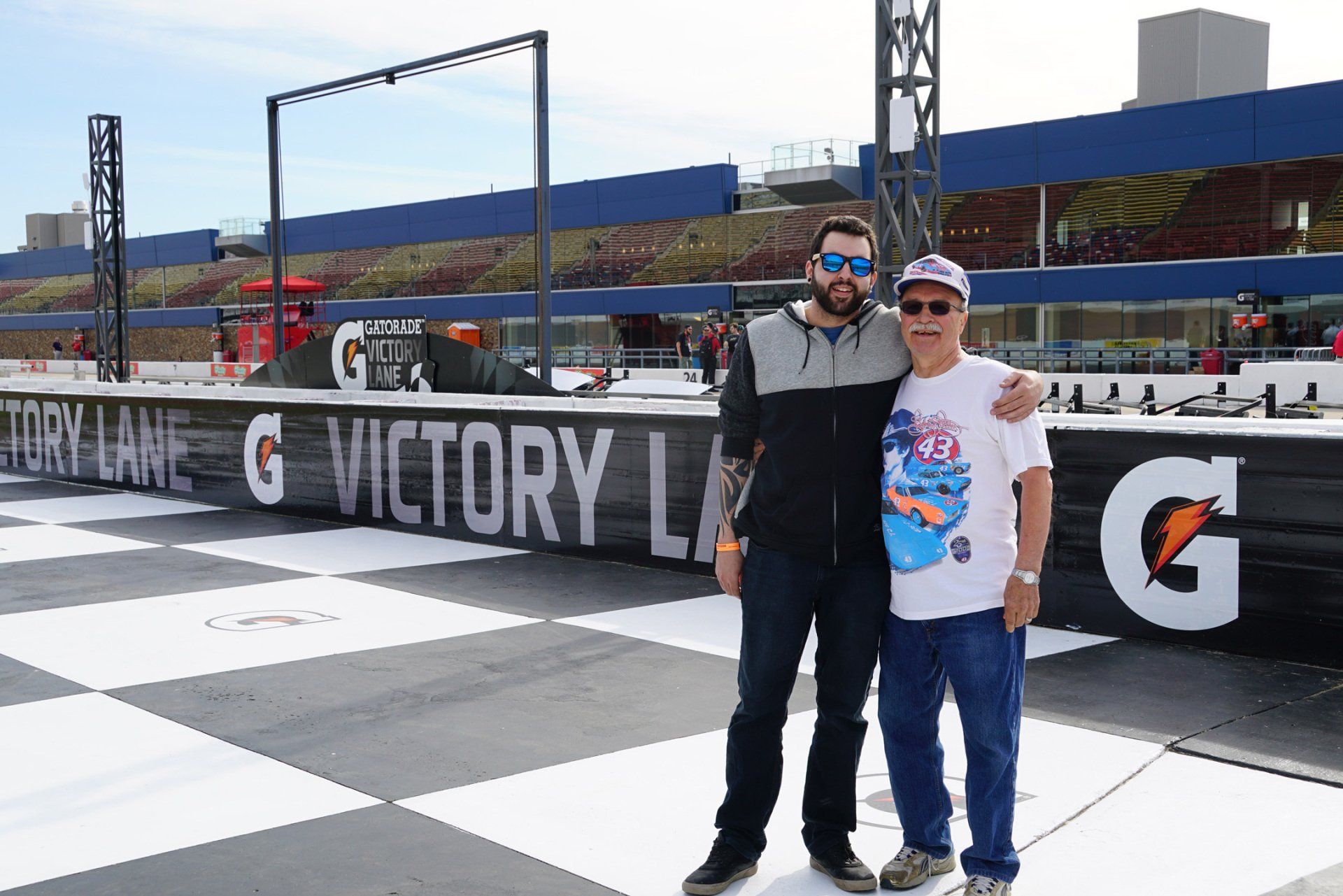 Two men standing in front of a sign that says victory lane