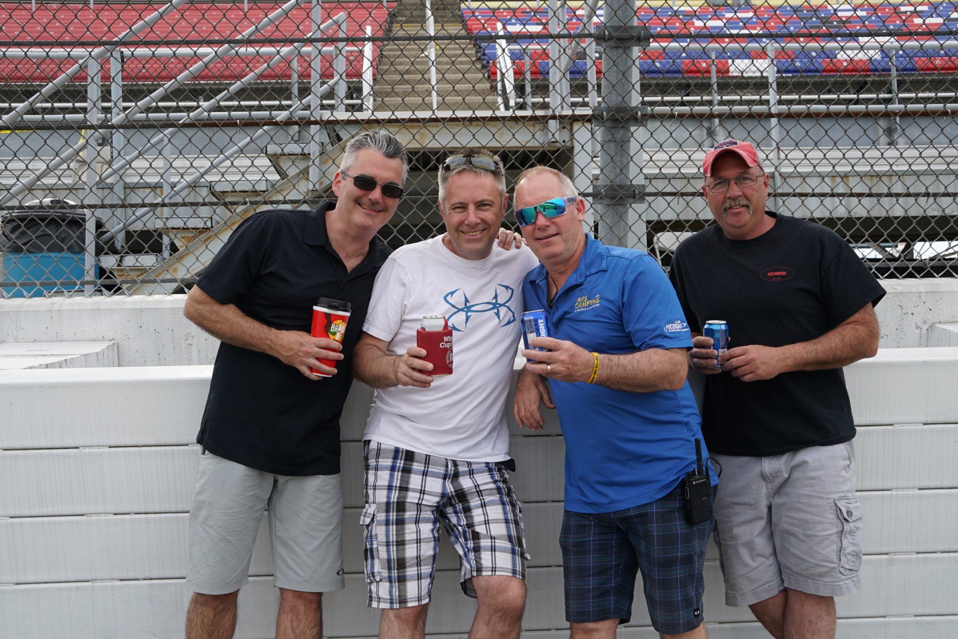 A group of men standing next to each other holding drinks.