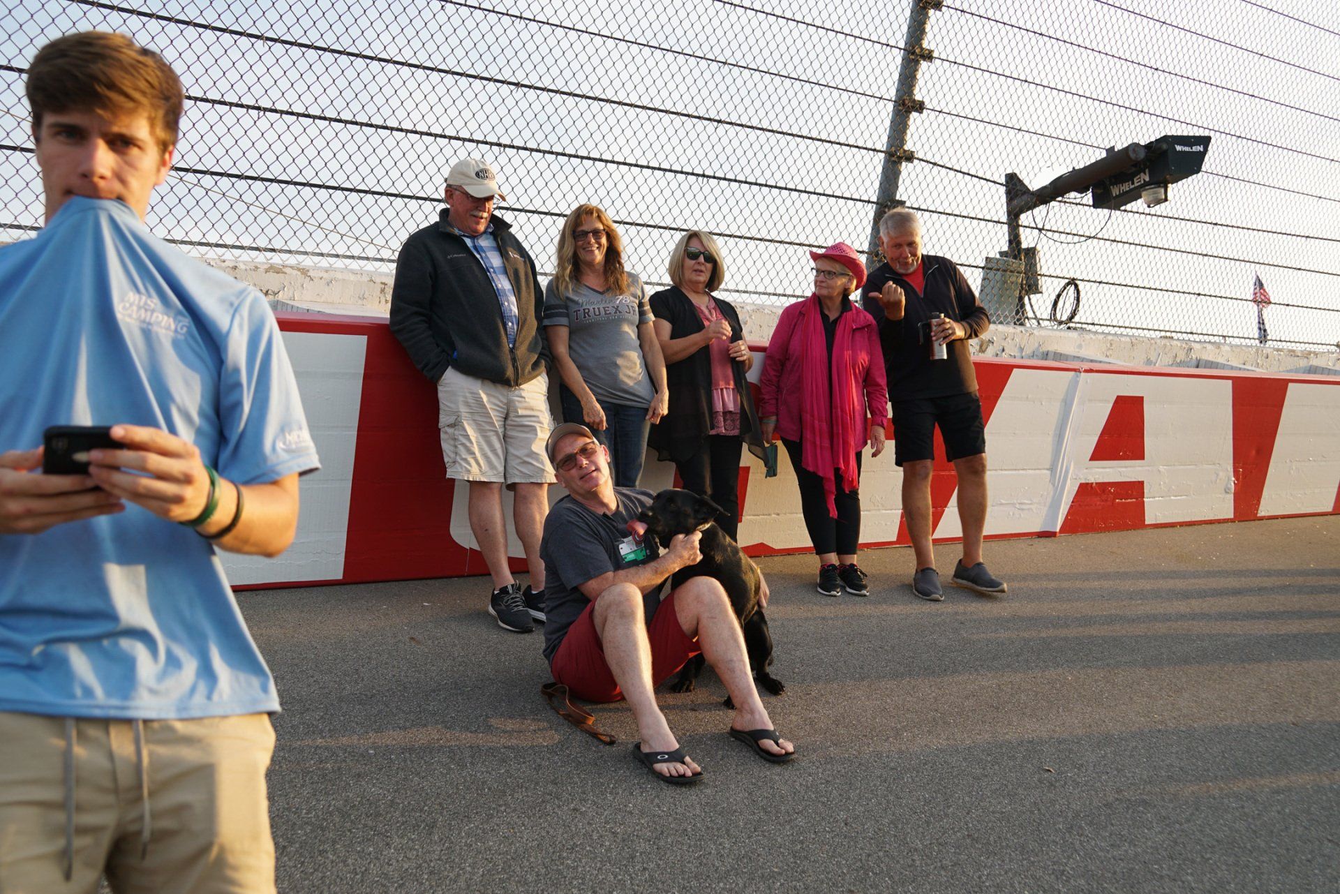 A group of people are standing in front of a wall that says nascar