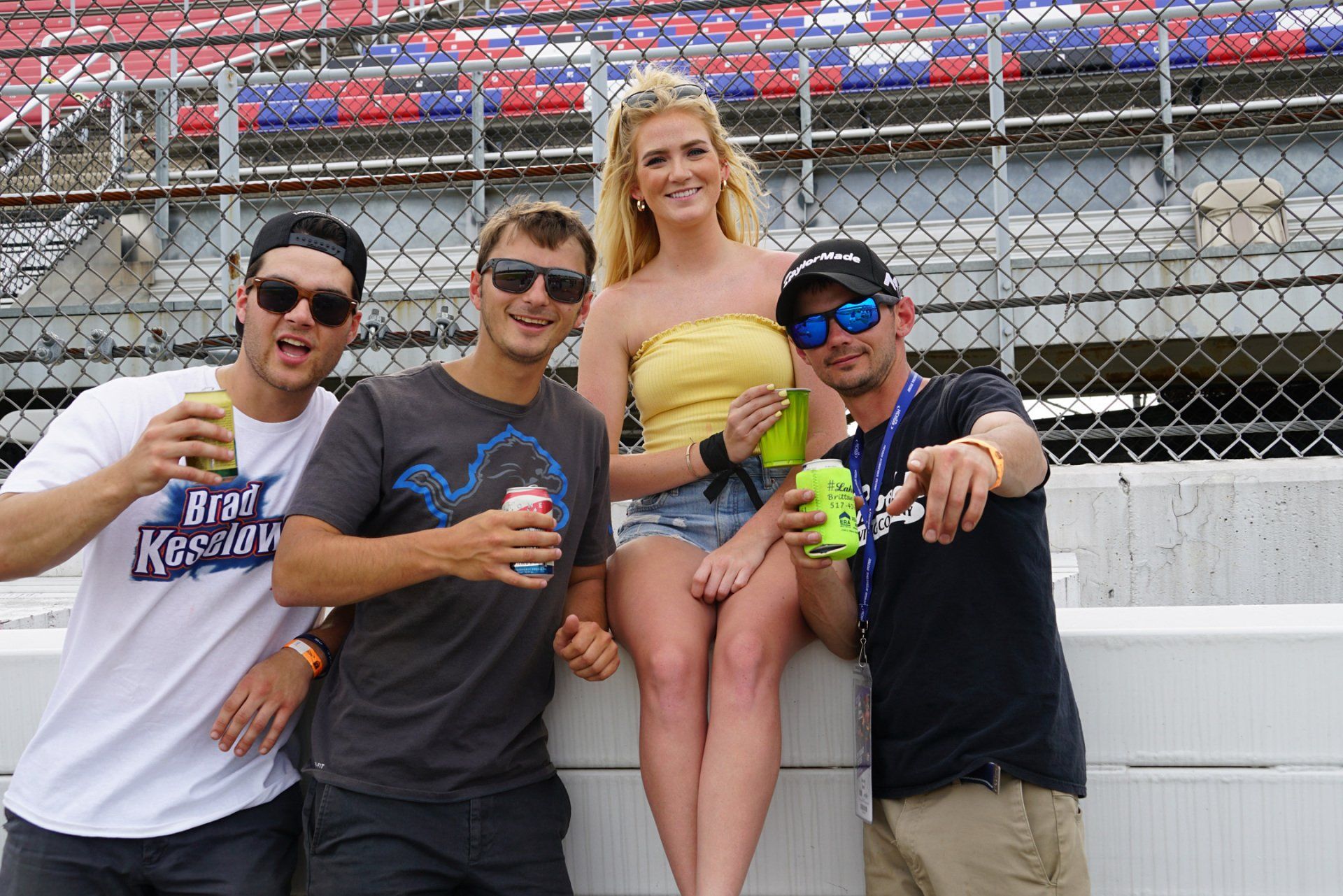 A group of people are posing for a picture with a woman sitting on a wall.