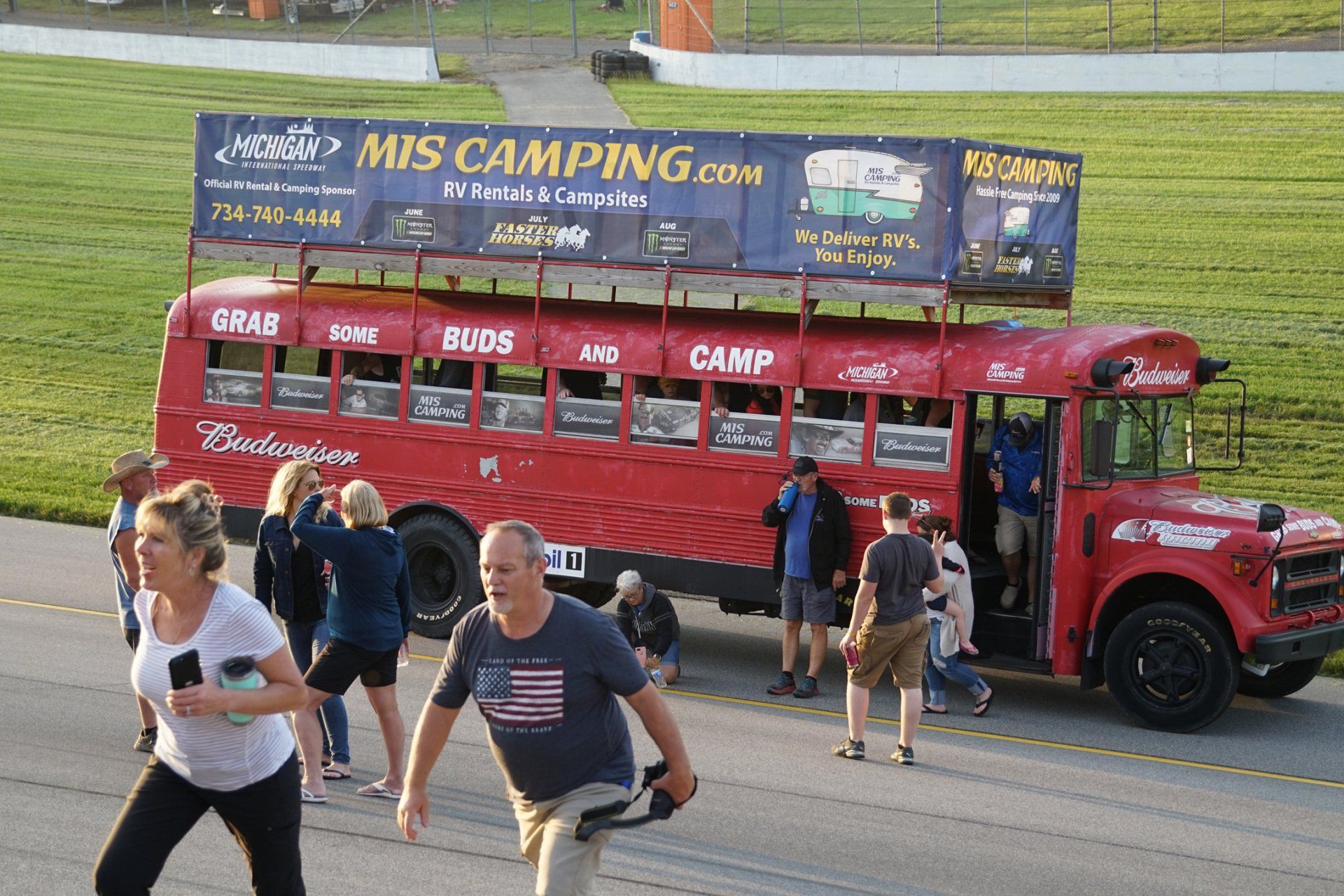 A red bus with a sign on top that says mis camping